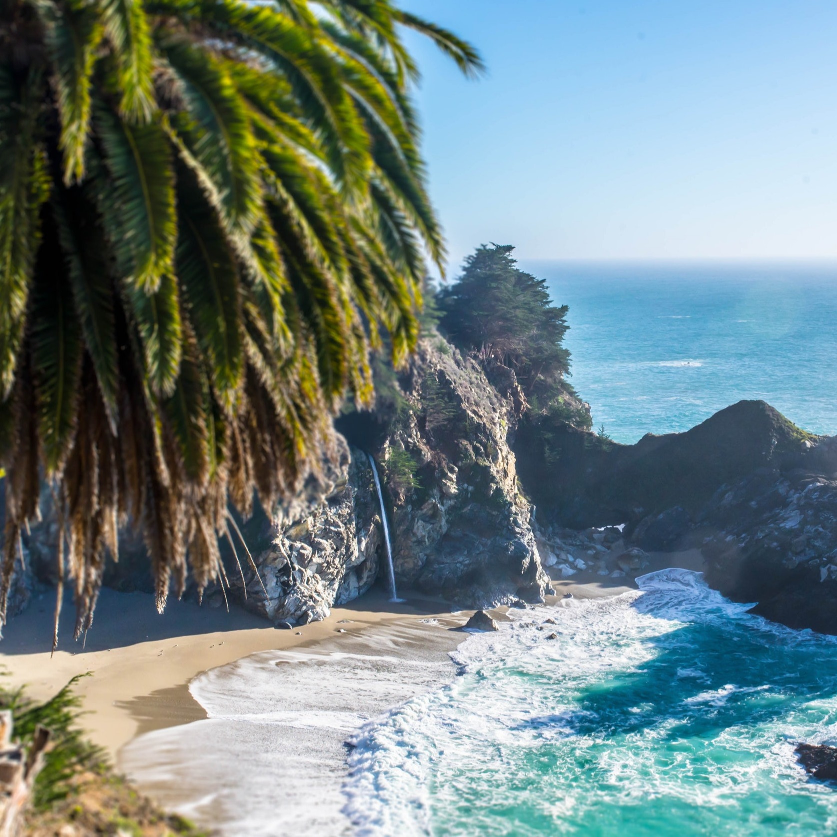 A rugged bay on the Central Coast of California, with craggy rocks and sky-blue waves