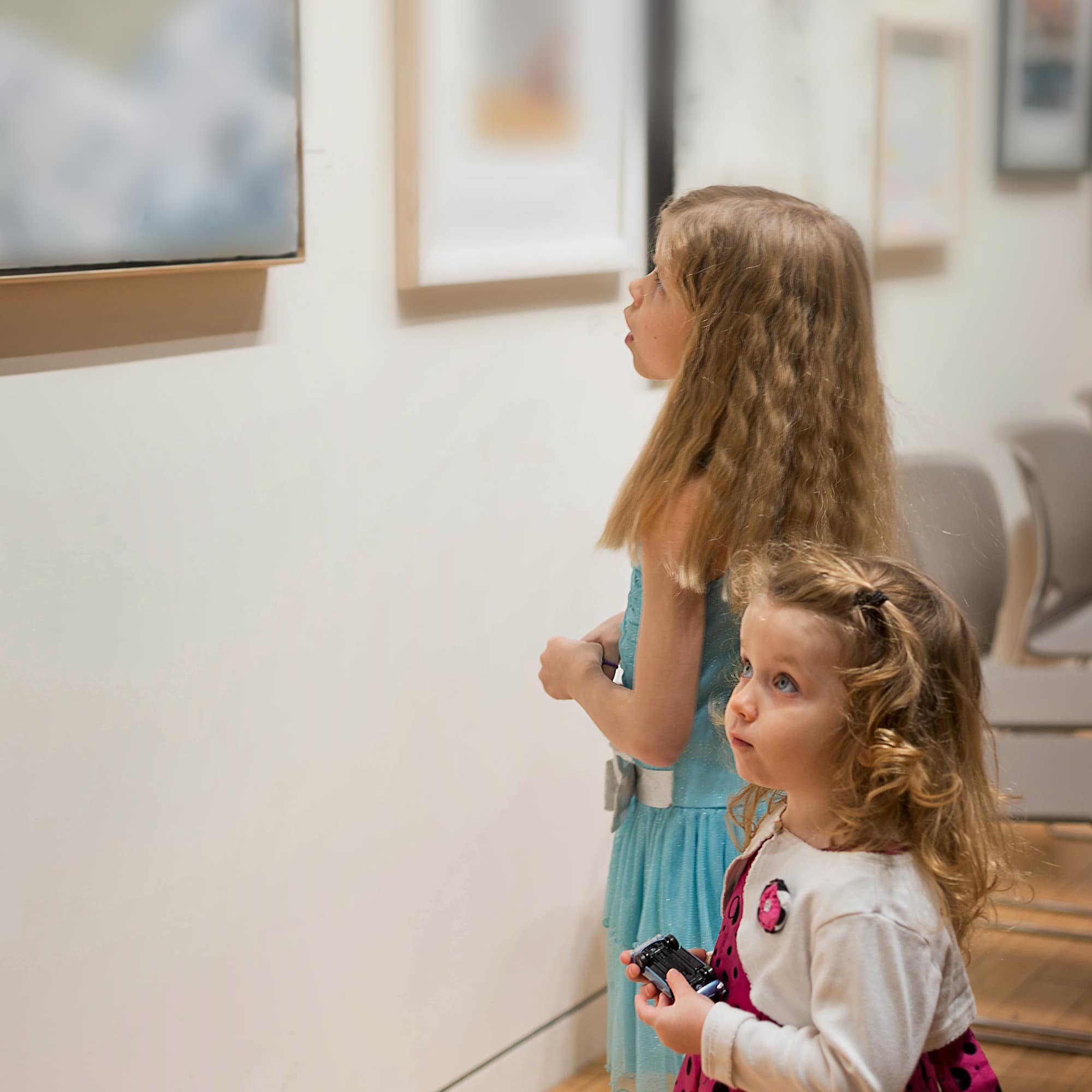 Two little girls looking at an art gallery exhibit