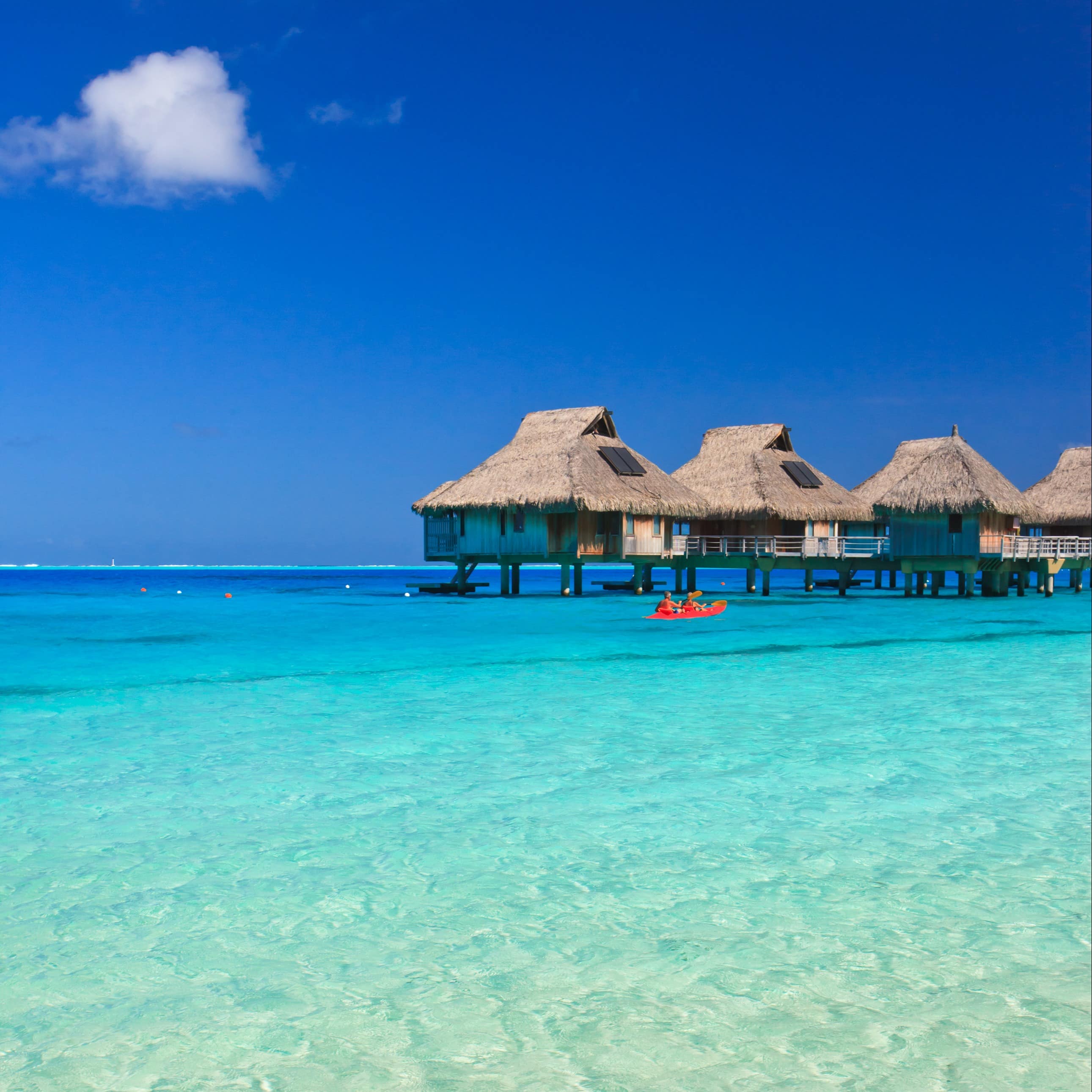 Overwater bungalows above crystal blue waters