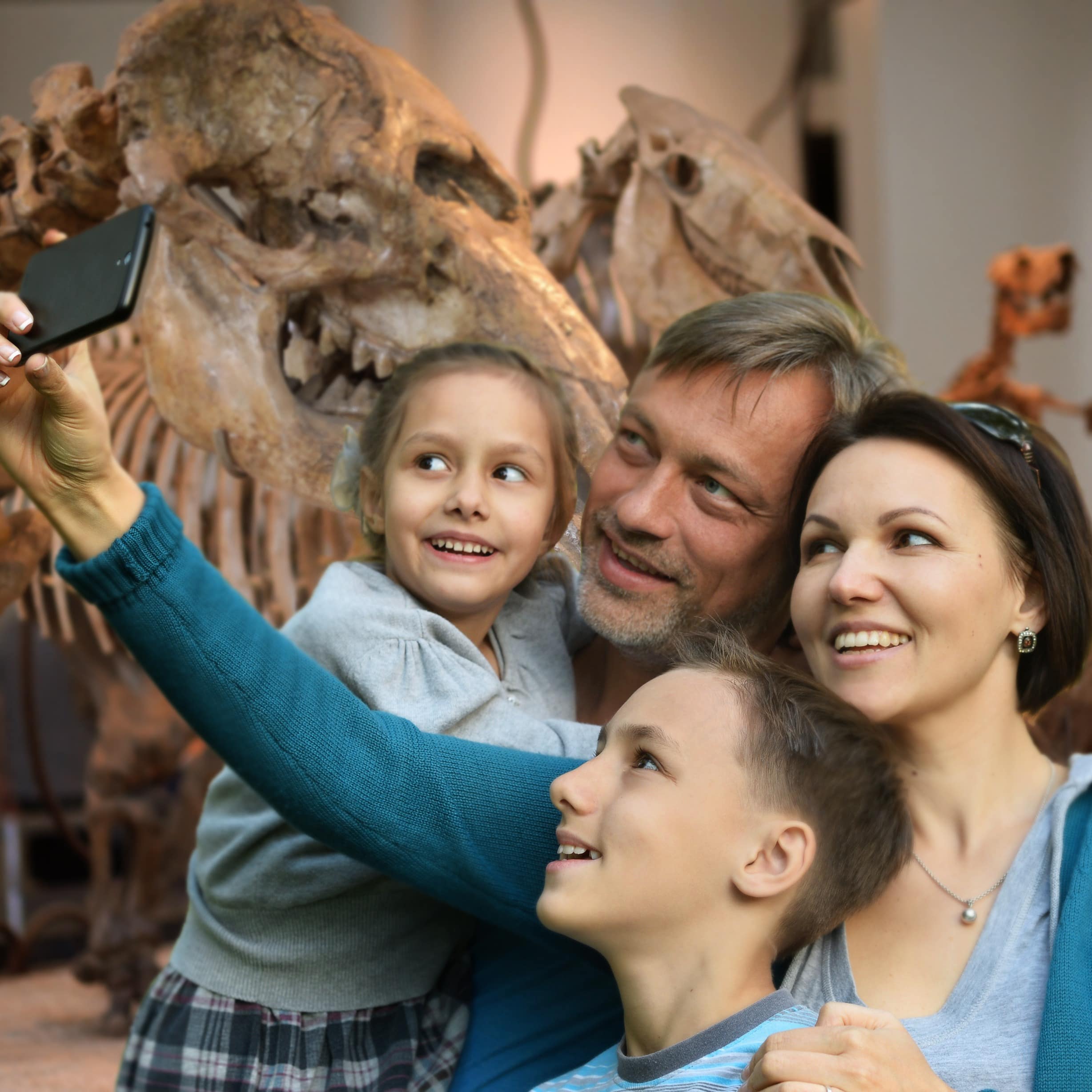 Family taking selfie in front of a dinosaur skeleton