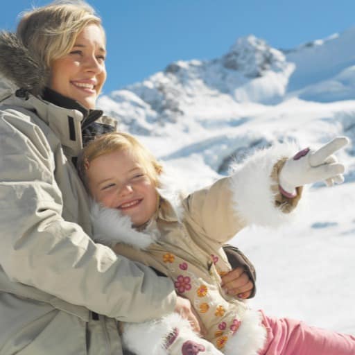 Mother and daughter sitting in the snow