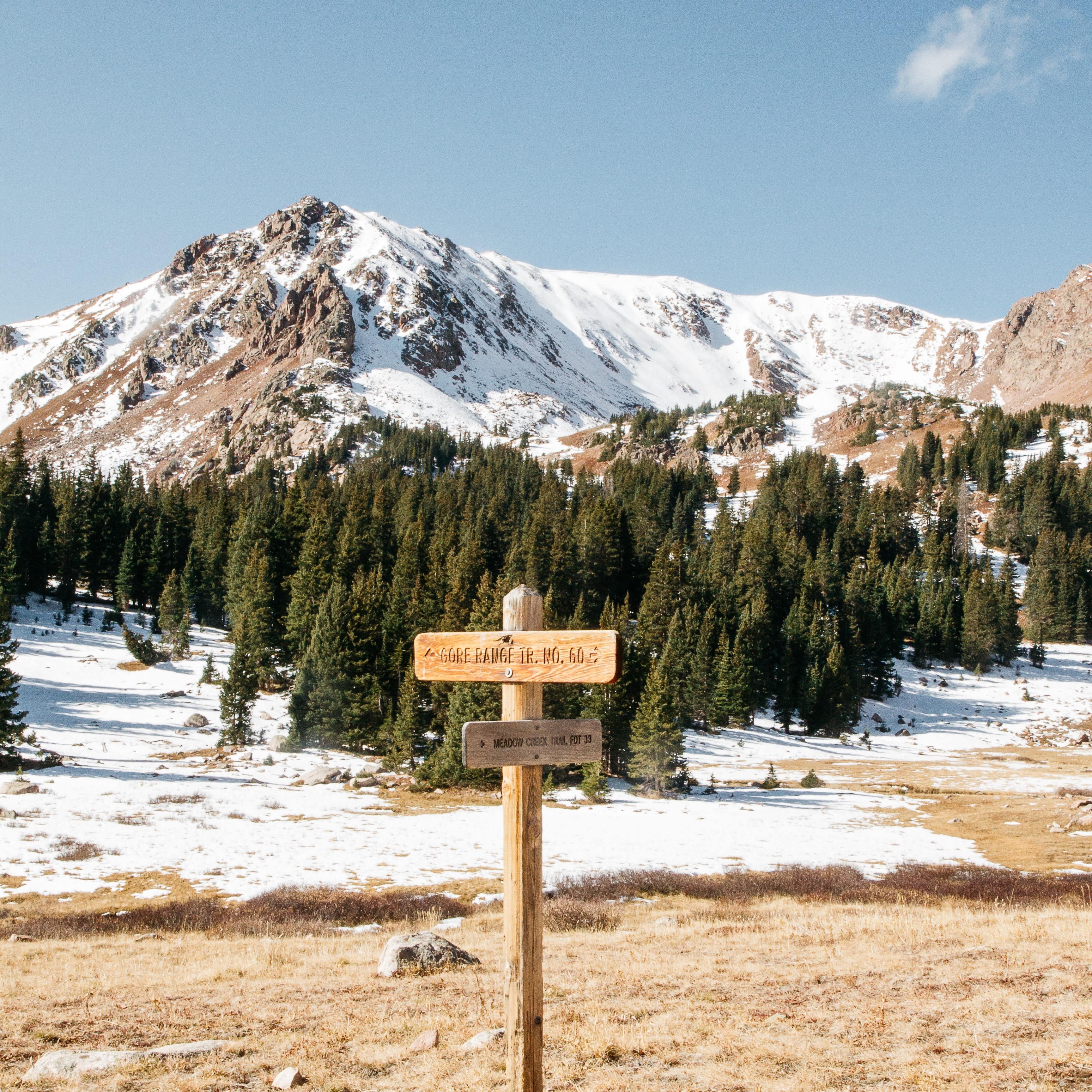 Wooden directional sign in front of a snow-covered Gore Mountain in upstate New York