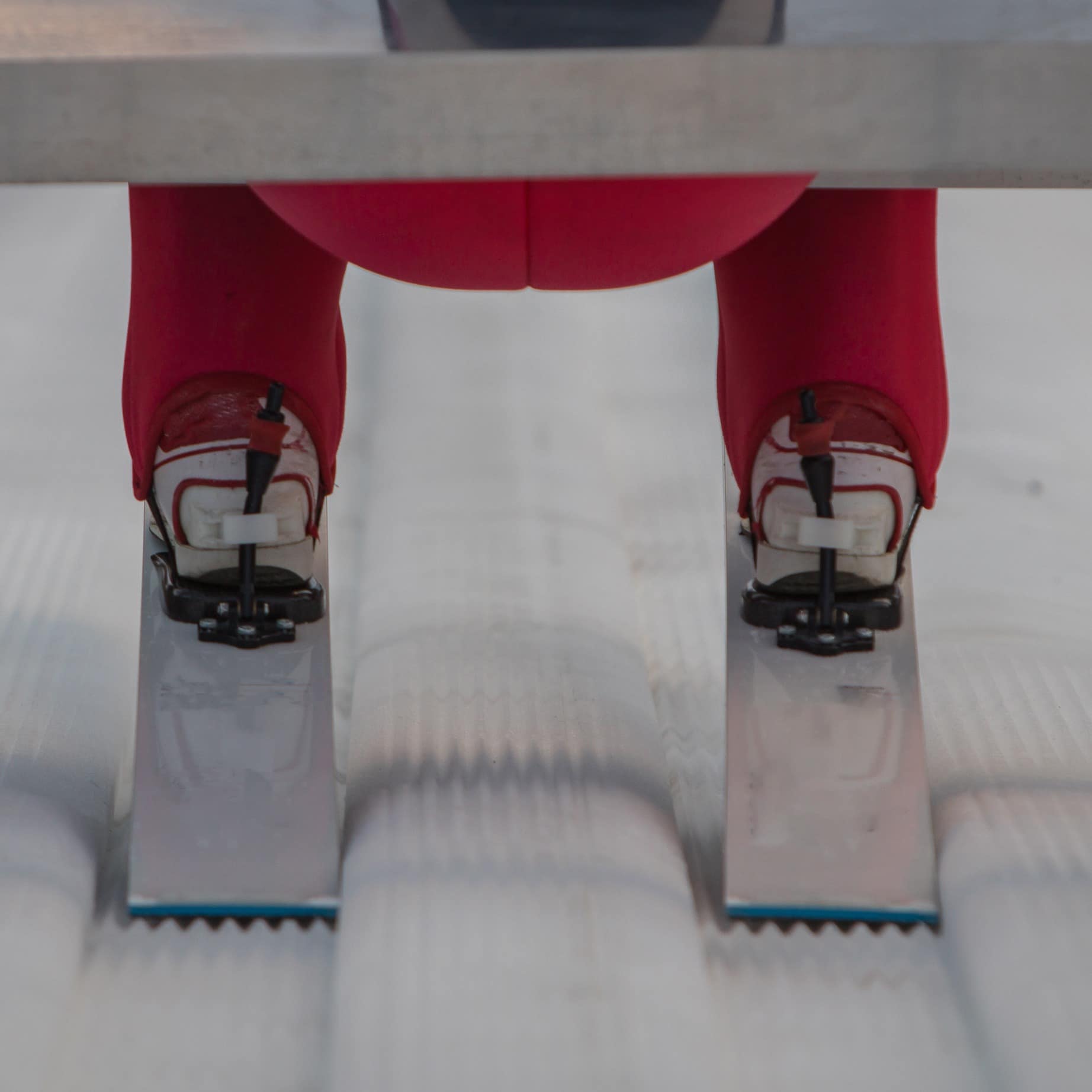 Visible details of shoes or boots, skis and the downward view from the jump