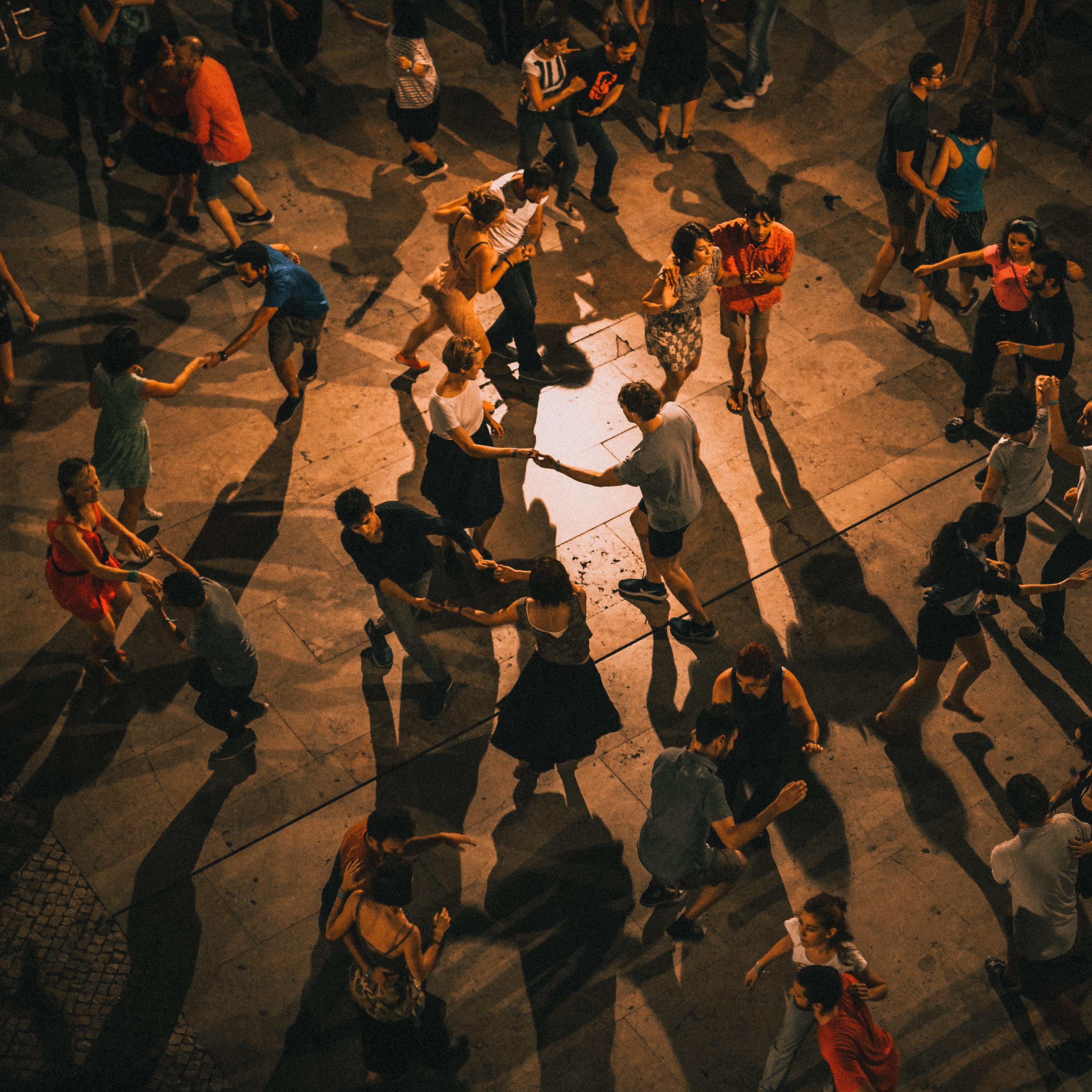Couples dancing at night in the street.