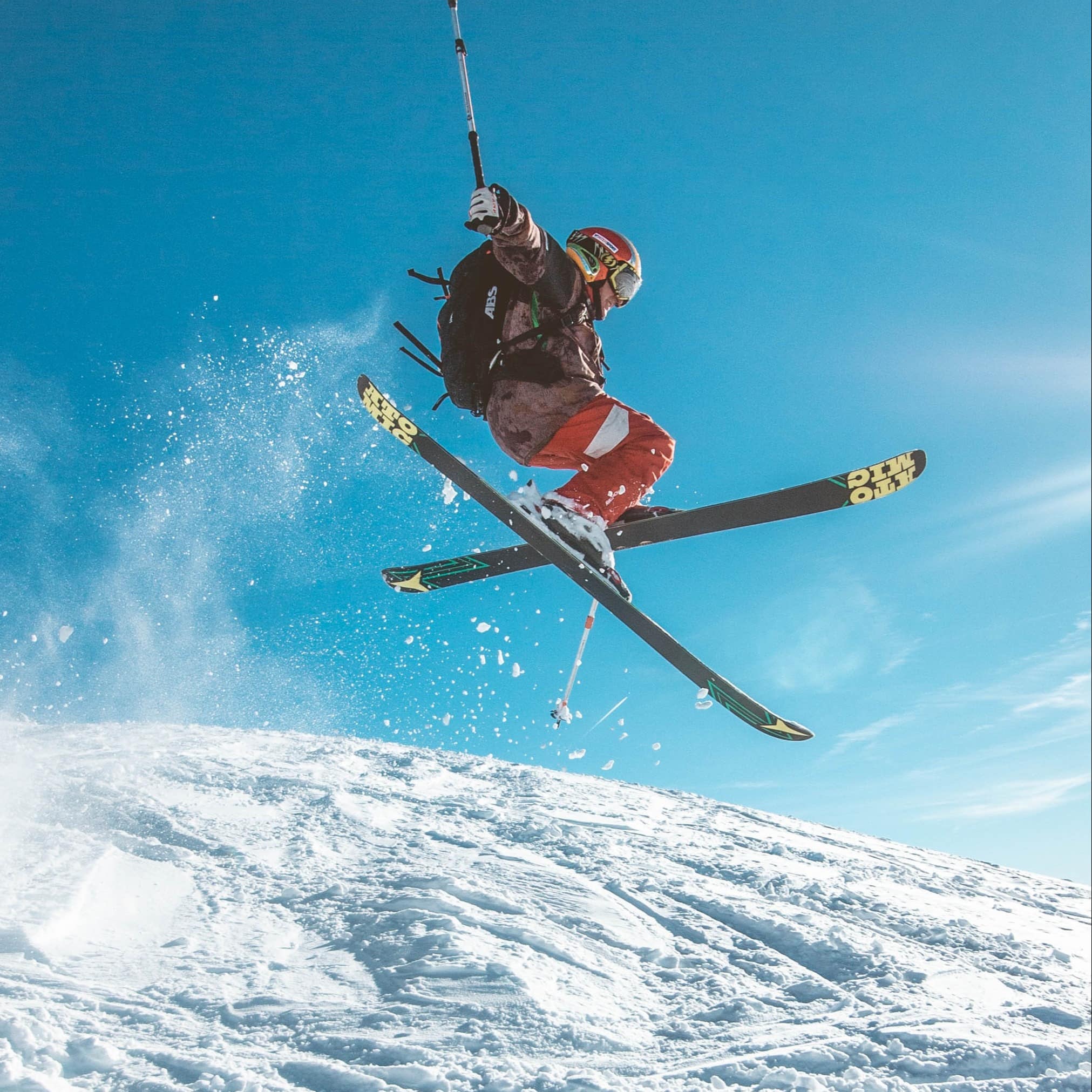 Skier doing a ski jump on a sunny day