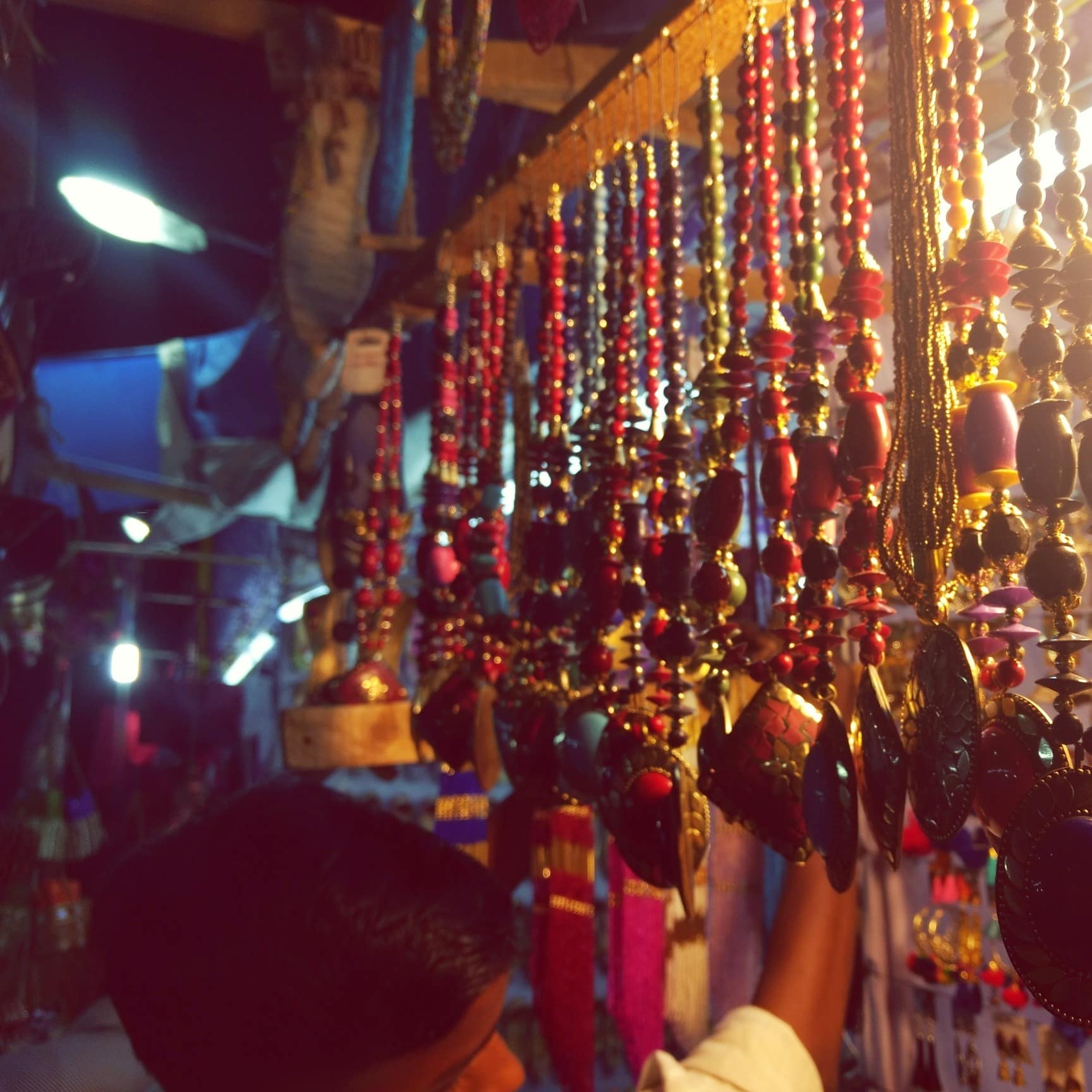 A market vendor selling pieces of jewellery at night