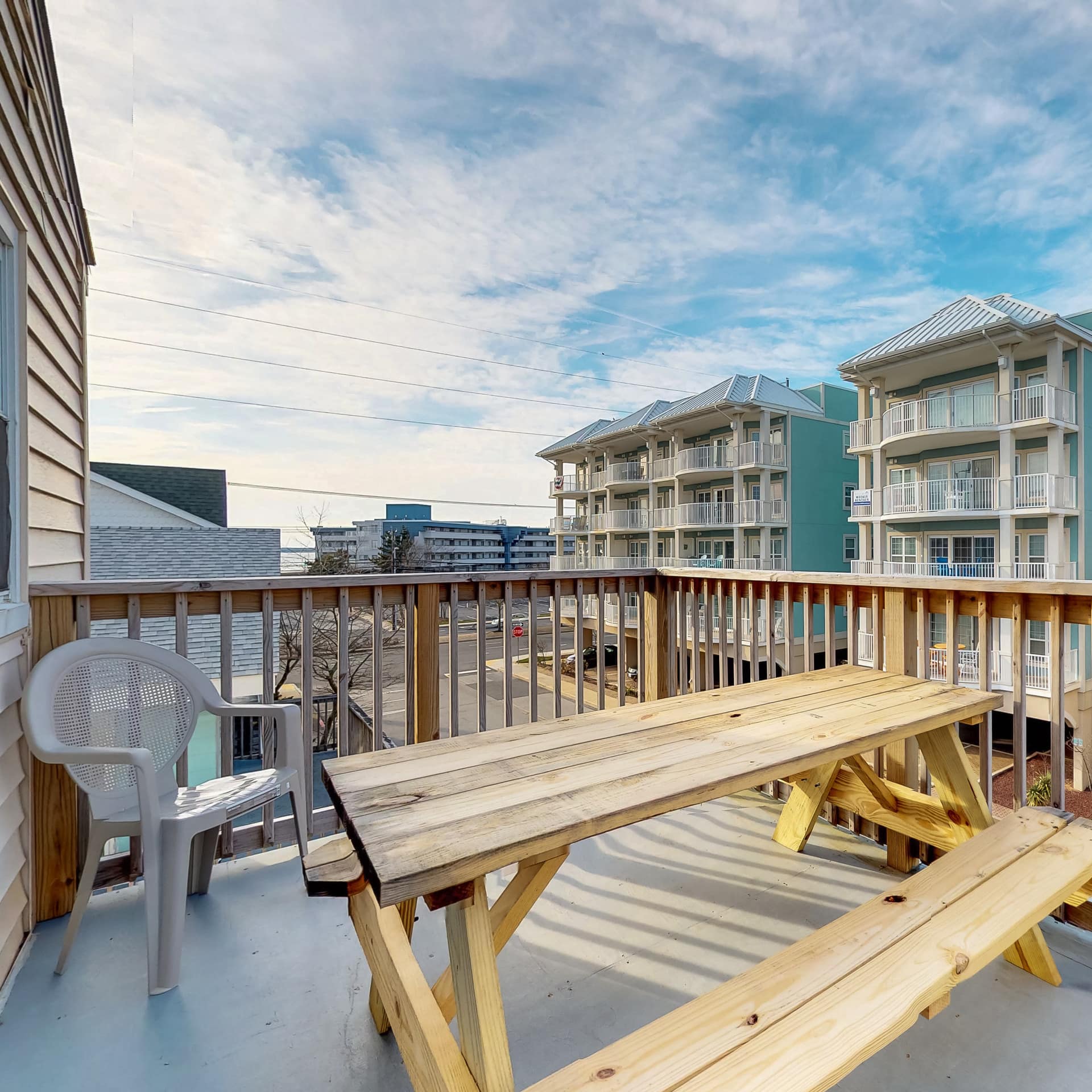 A pub-style picnic table sits on the terrace of a condominium