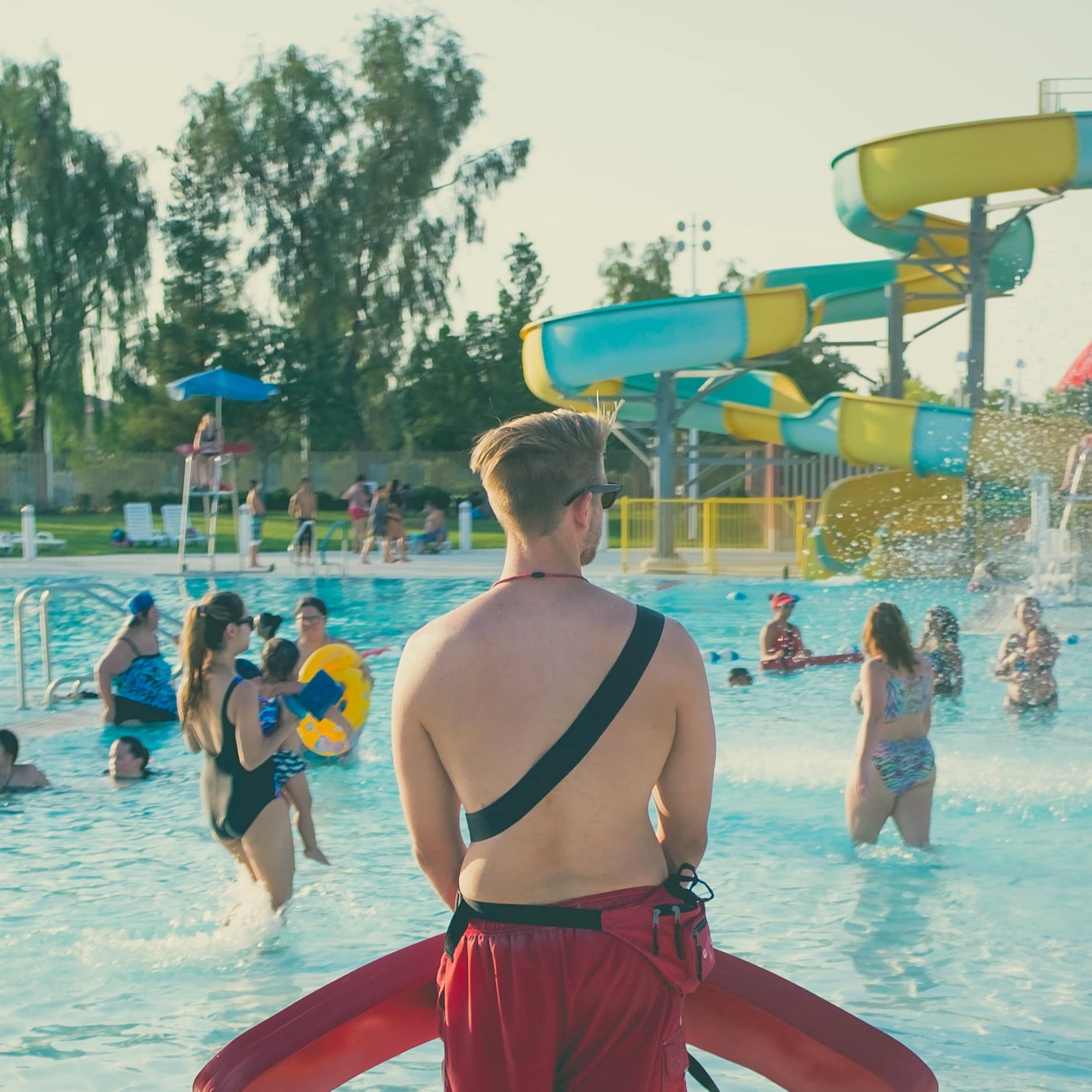 Families playing in the waterpark with the lifeguards standing by