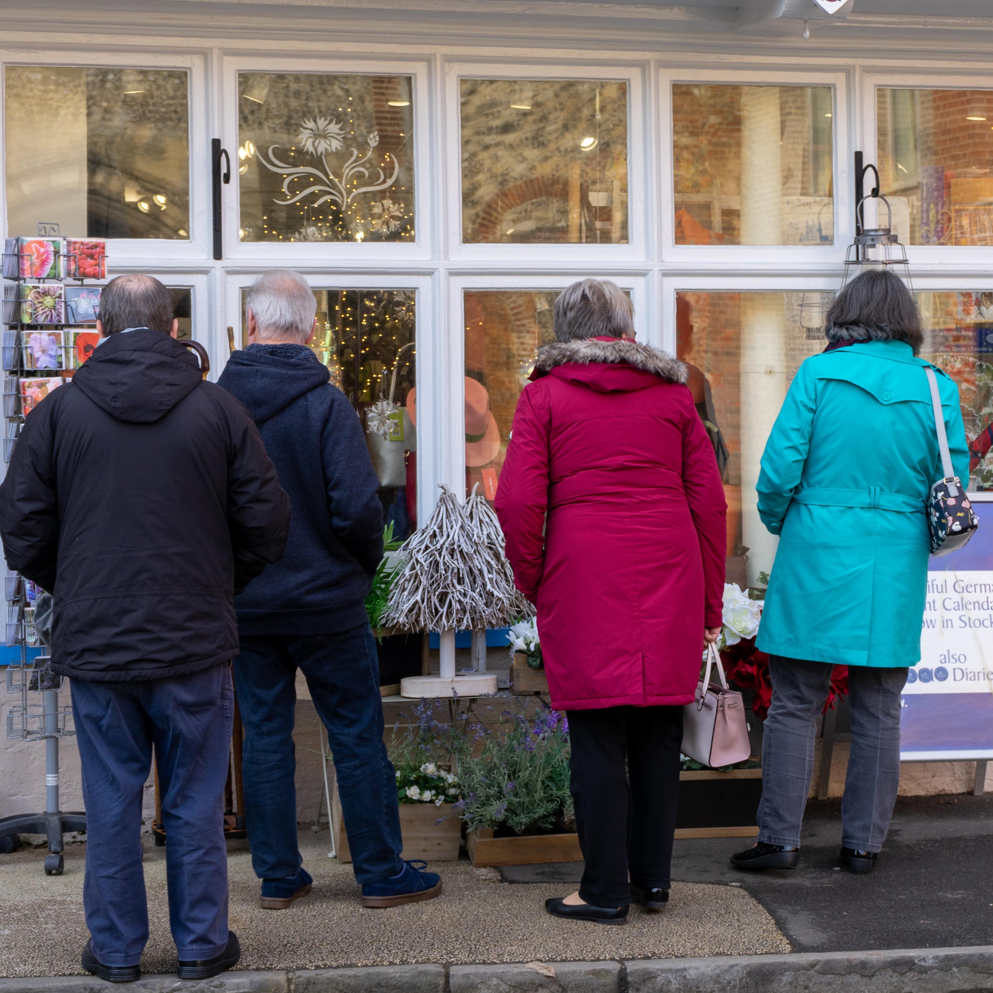 Two couples looking through a shops window