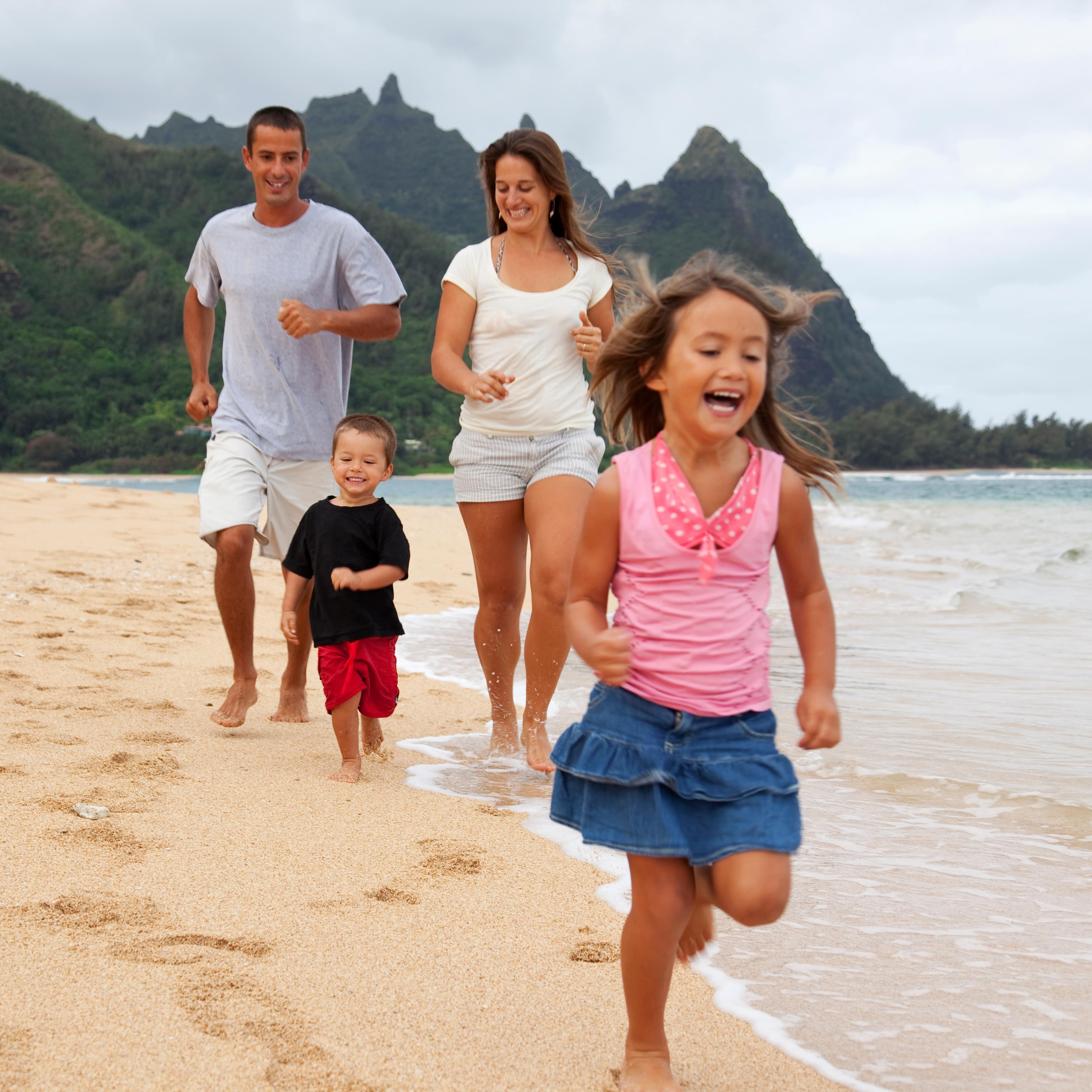 Family running along the shoreline