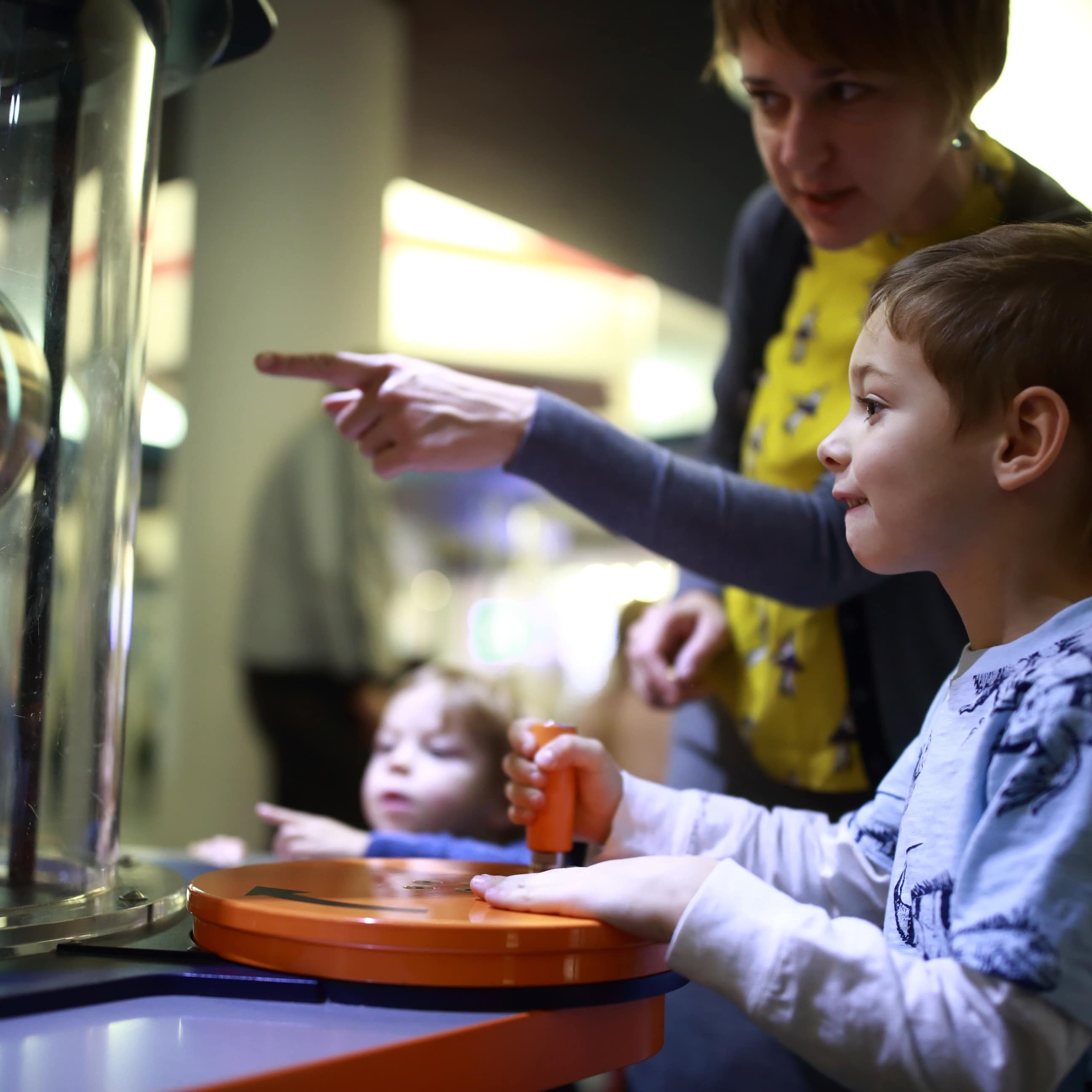 Mother and son learning from science exhibit at museum
