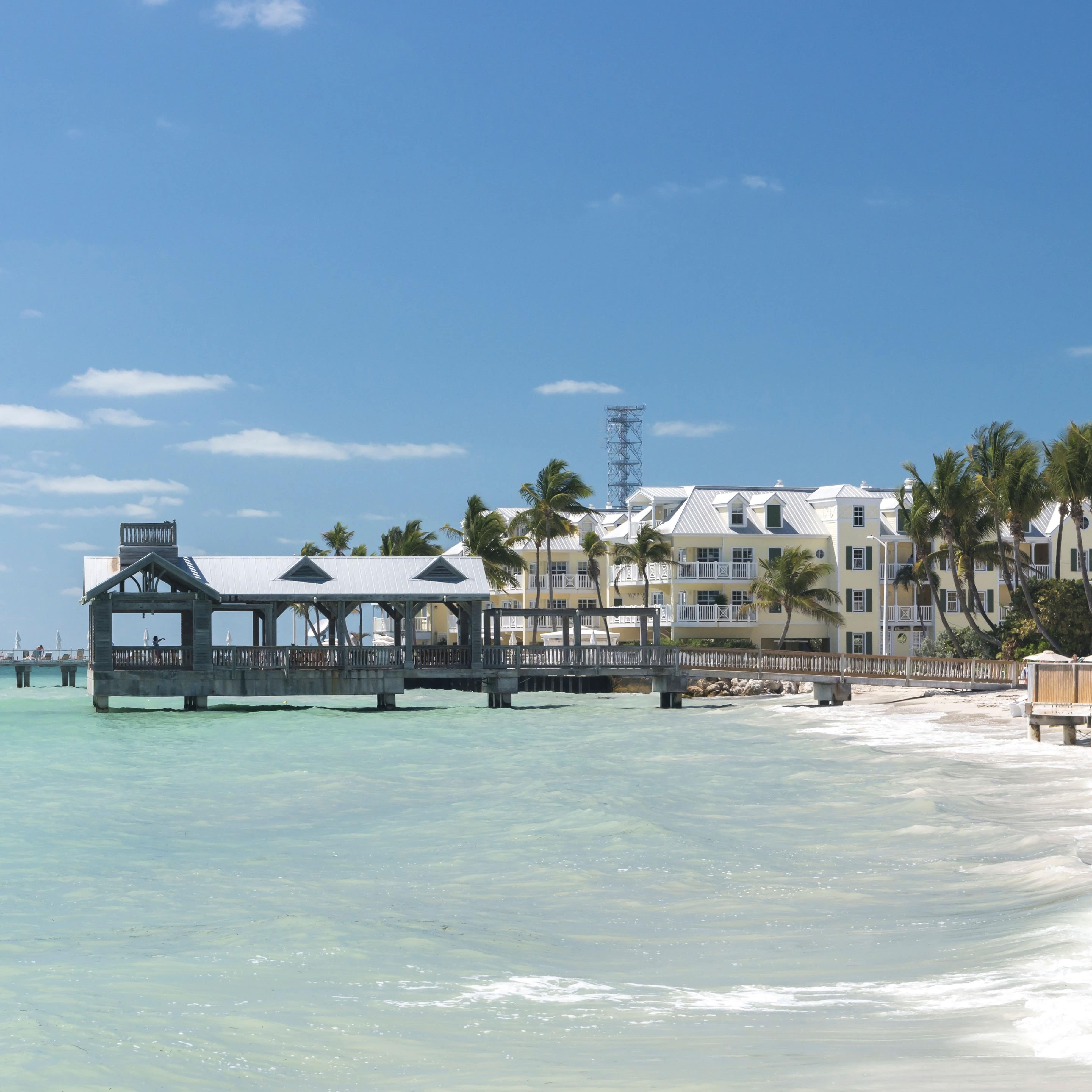 Bright blue sunny day showing a covered pier and condos on the beach in Key West, Florida, USA