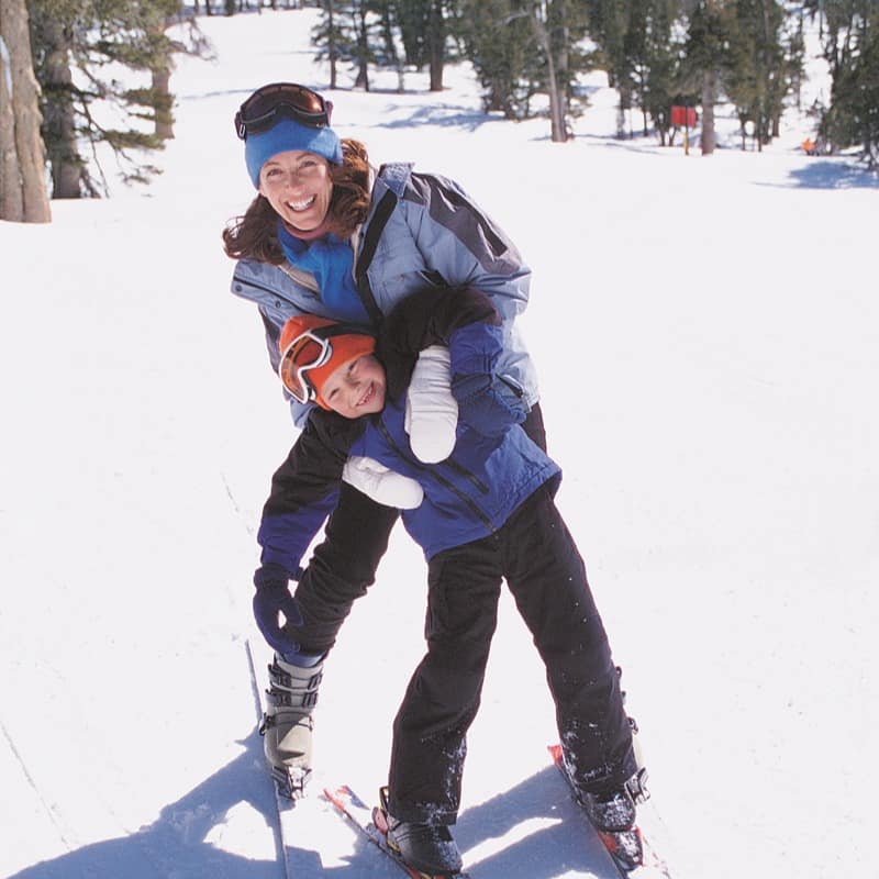 Mother and son posing for a picture before making their way down the snow-covered mountain slopes