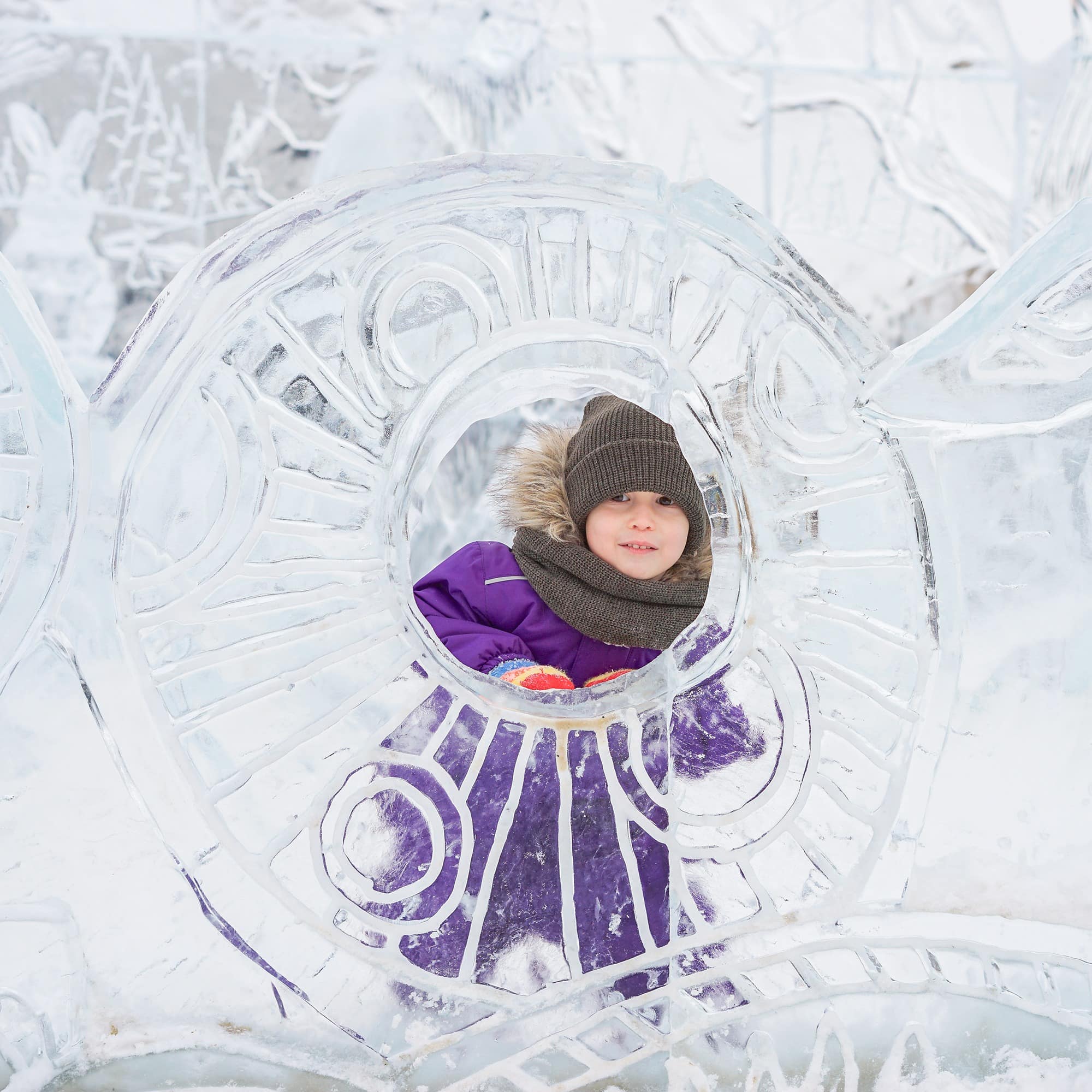 Little boy hiding behind an ice sculpture