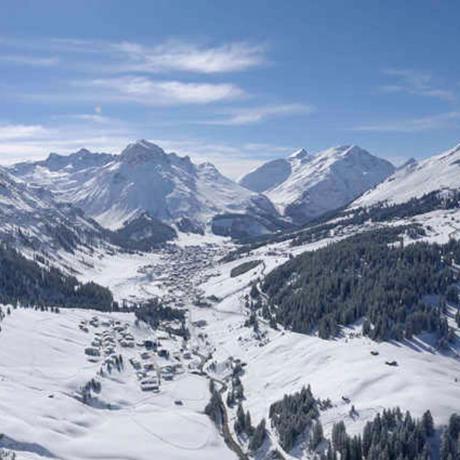 Wide-open view of the ski run and mountain range from the top of a mountain in Lech