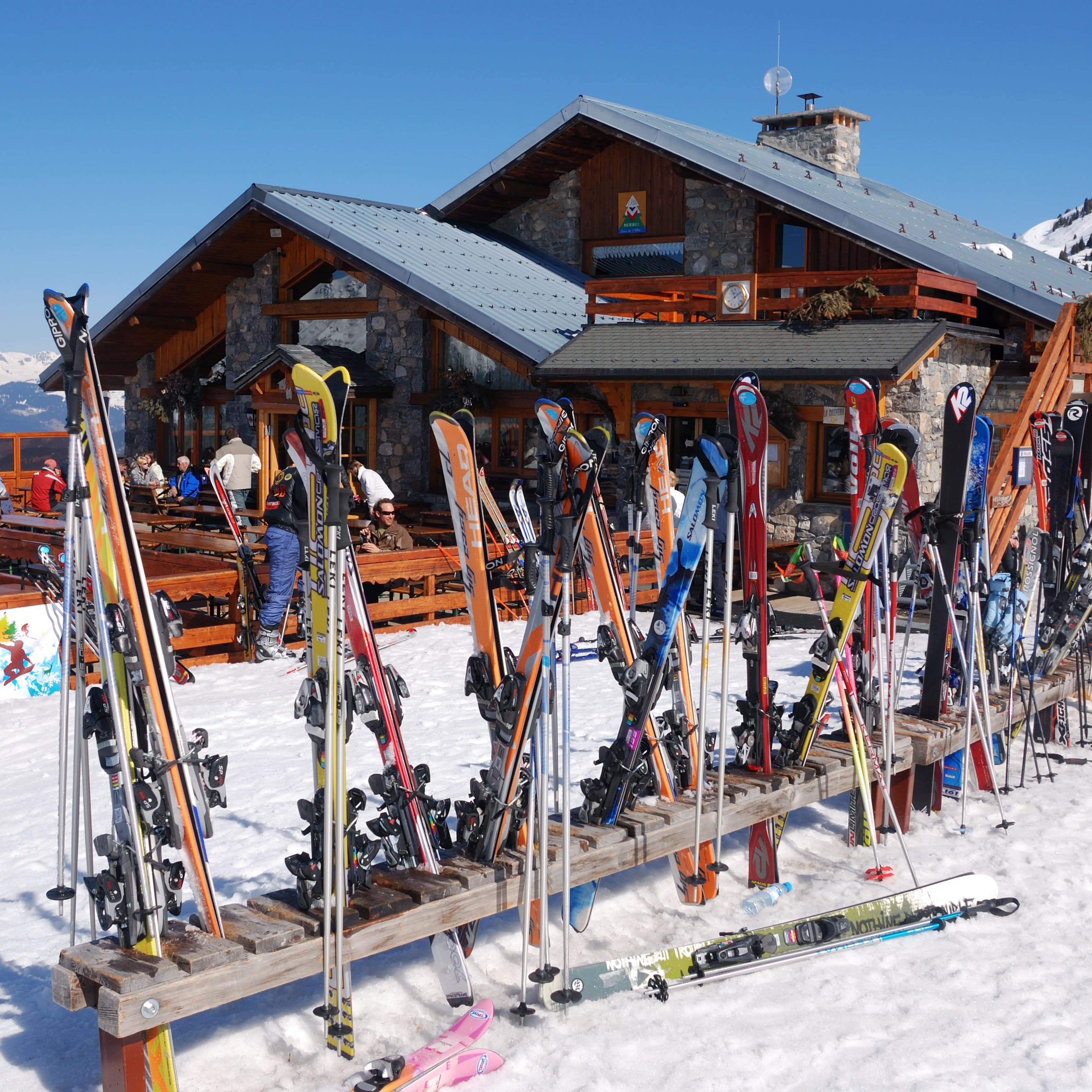 Skis and other equipment waiting by the benches outside of the rental shop