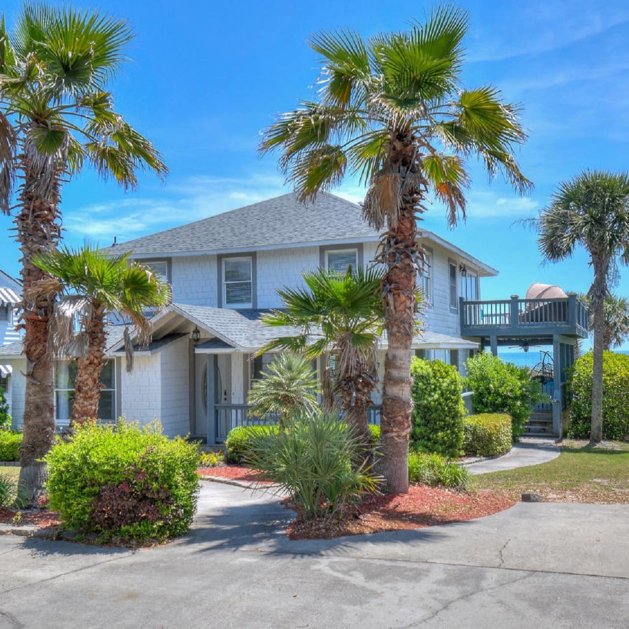 Beach condo with ocean views surrounded by palms