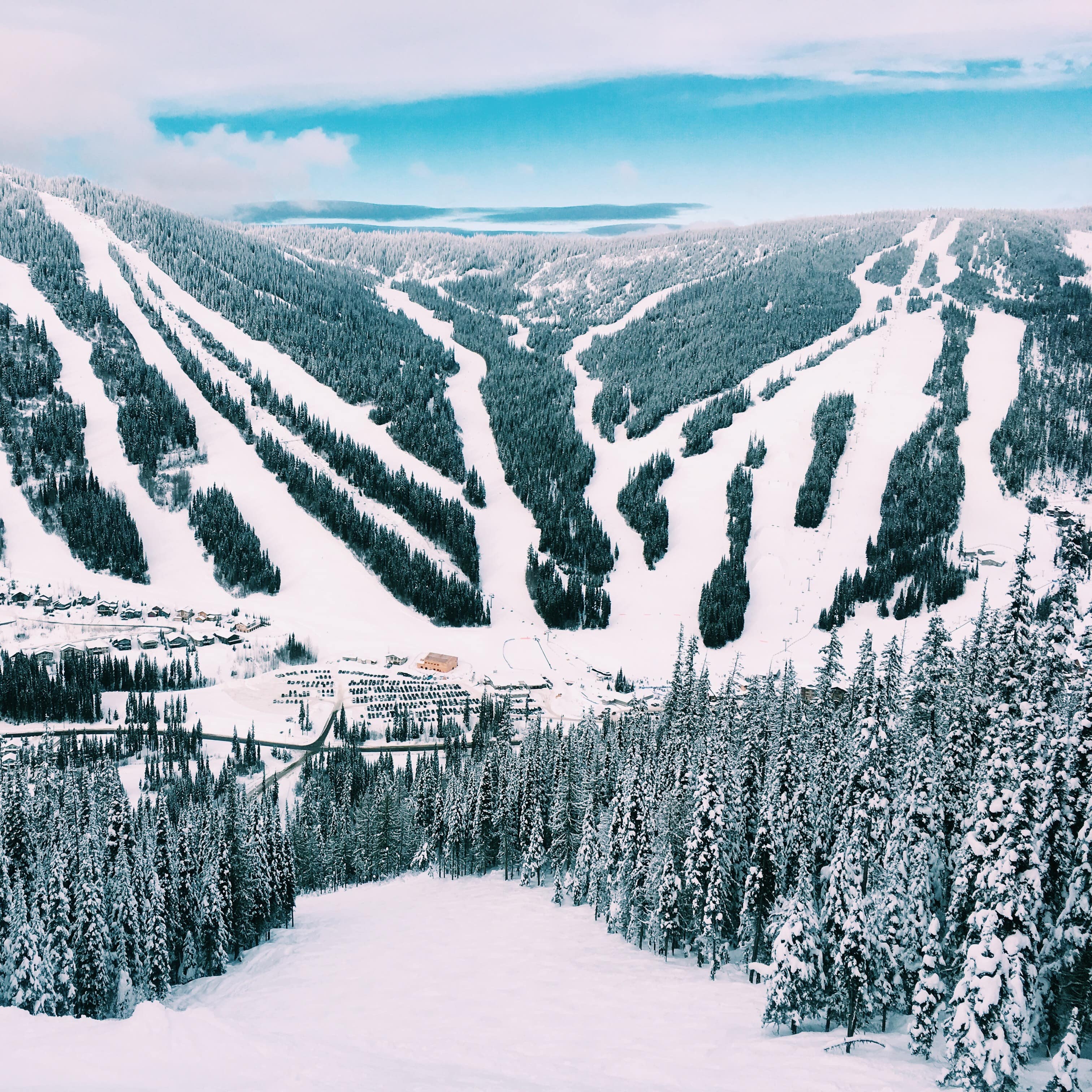Aerial view of snowy slopes coming down the mountains