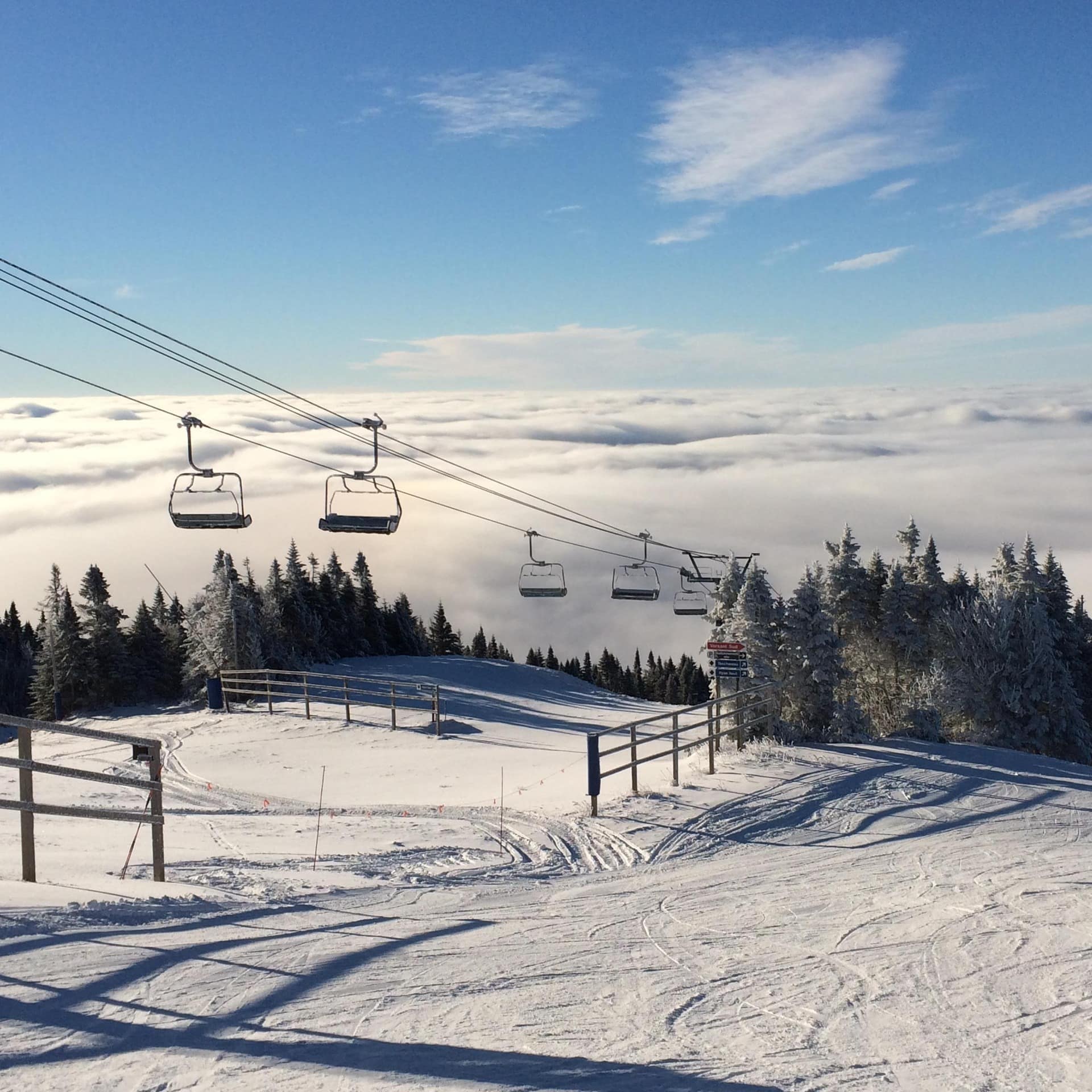 View of the ski lift, slopes, and clouds surrounding Mont Tremblant