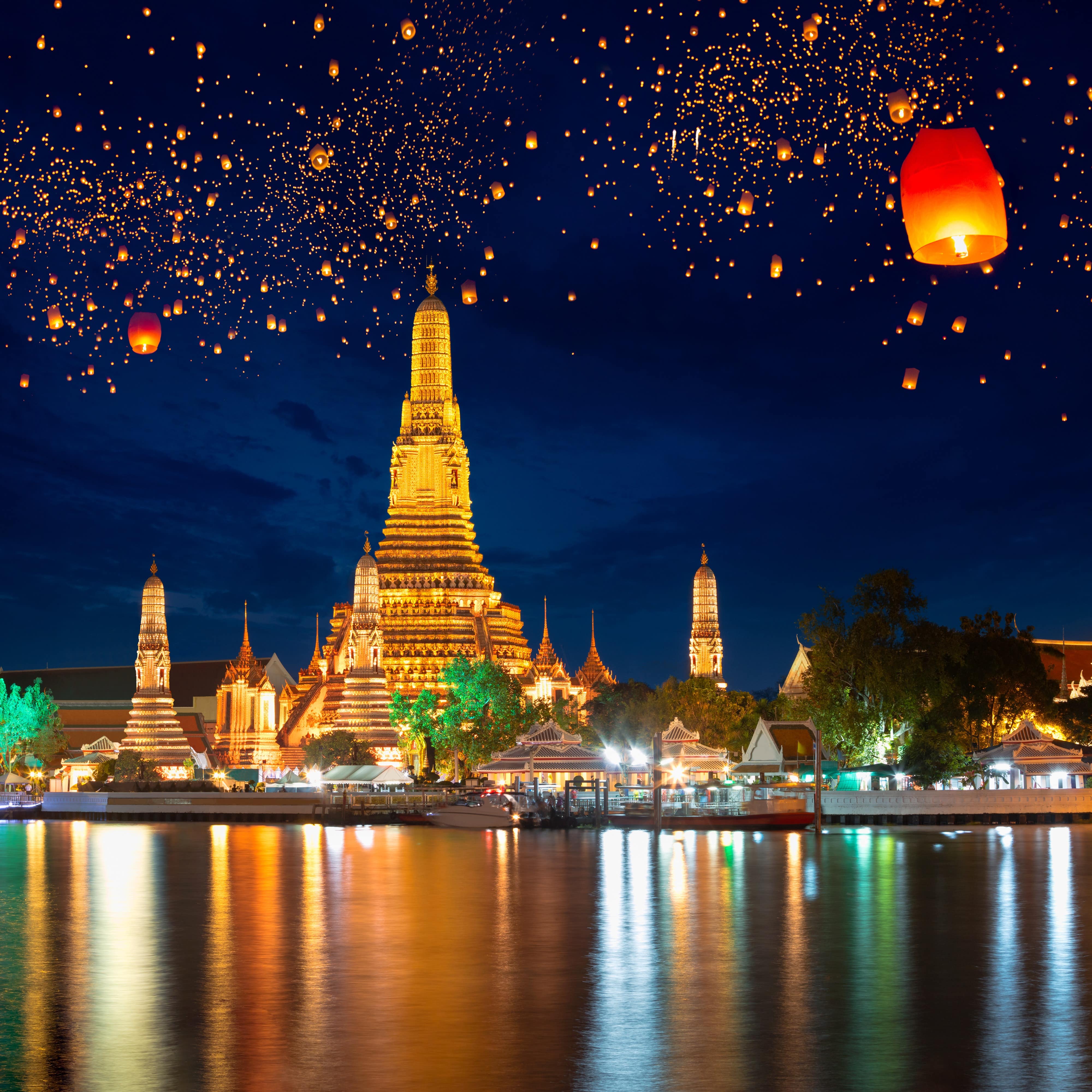 Wat Arun temple with krathong lanterns filling the night-sky in Bangkok