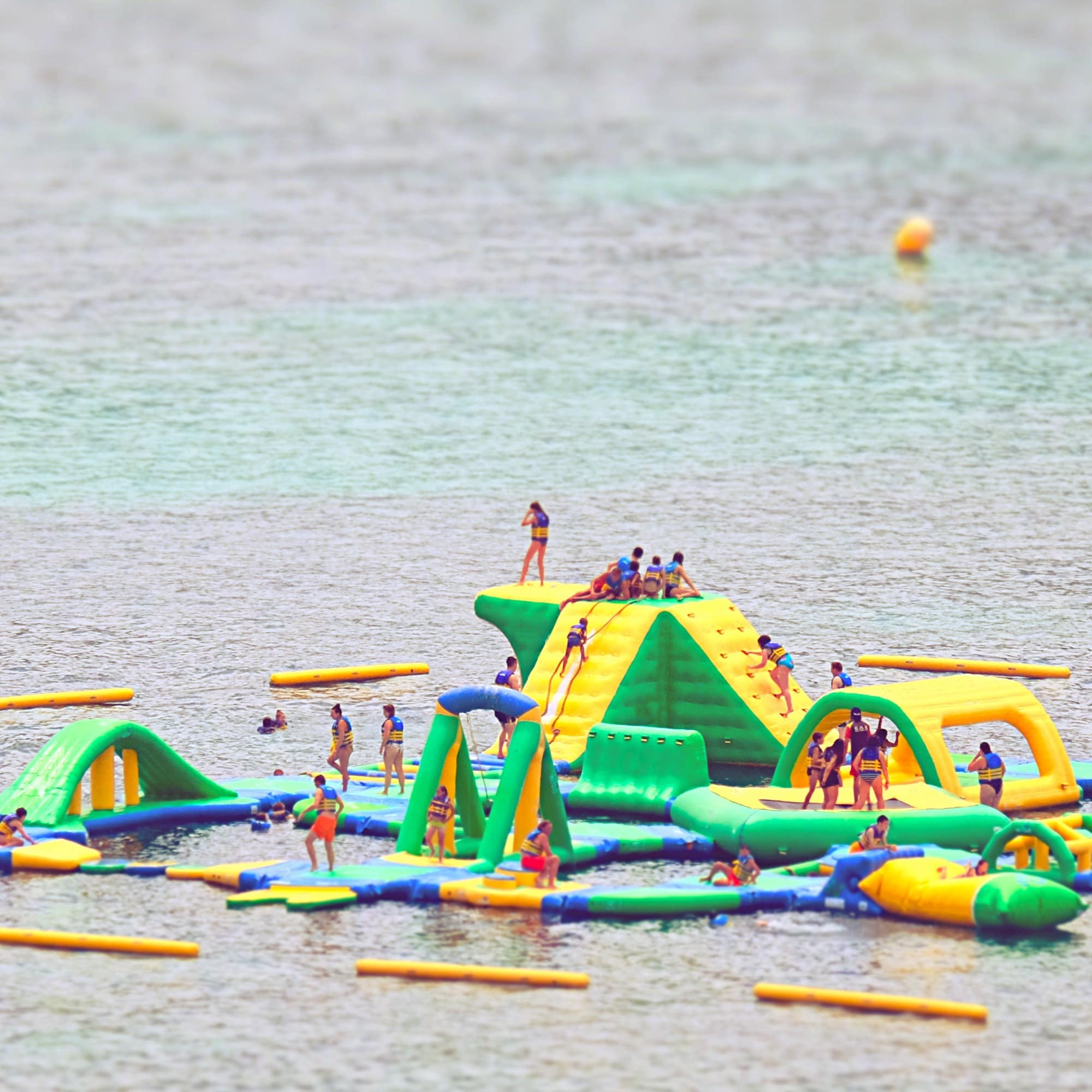 People playing on inflatables in water