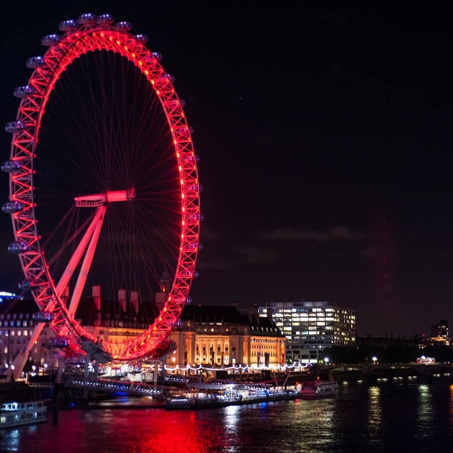 The London eye lit up red at night. 