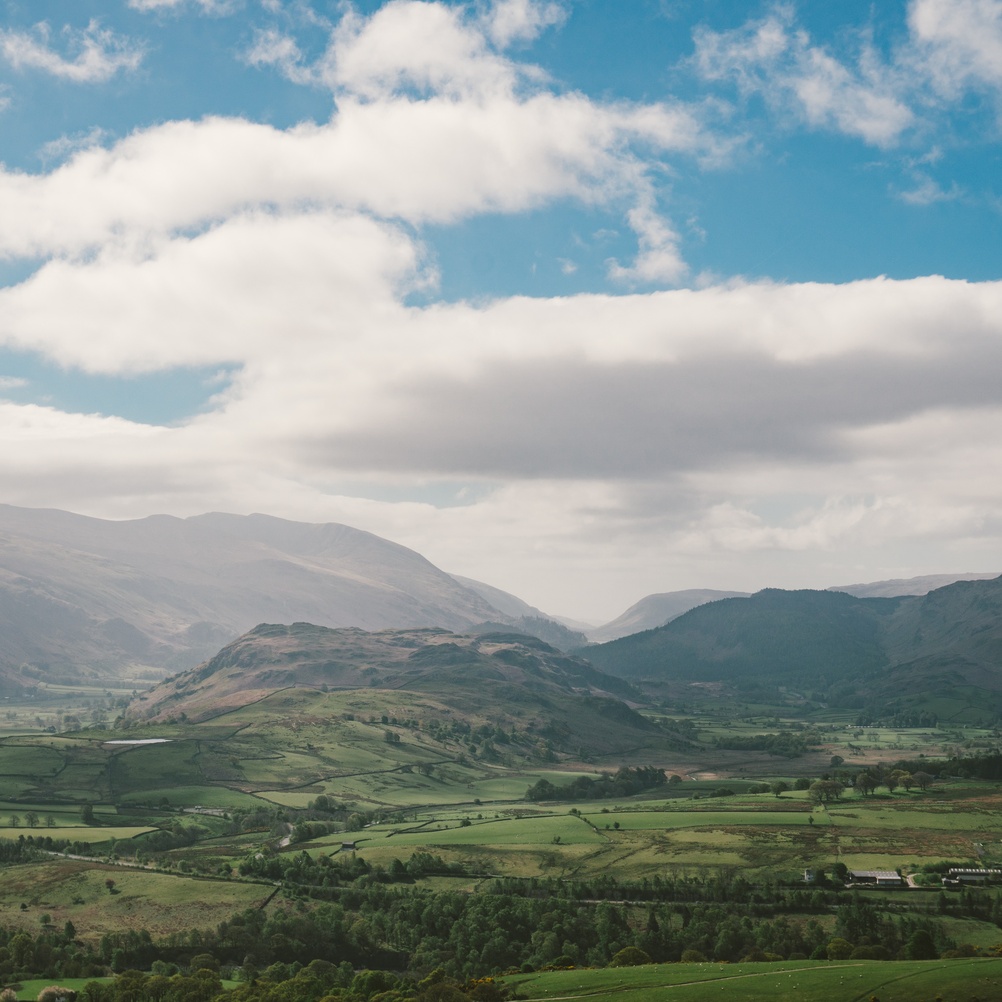 The rolling green hills and blue sky of puffy white clouds of Keswick, UK 