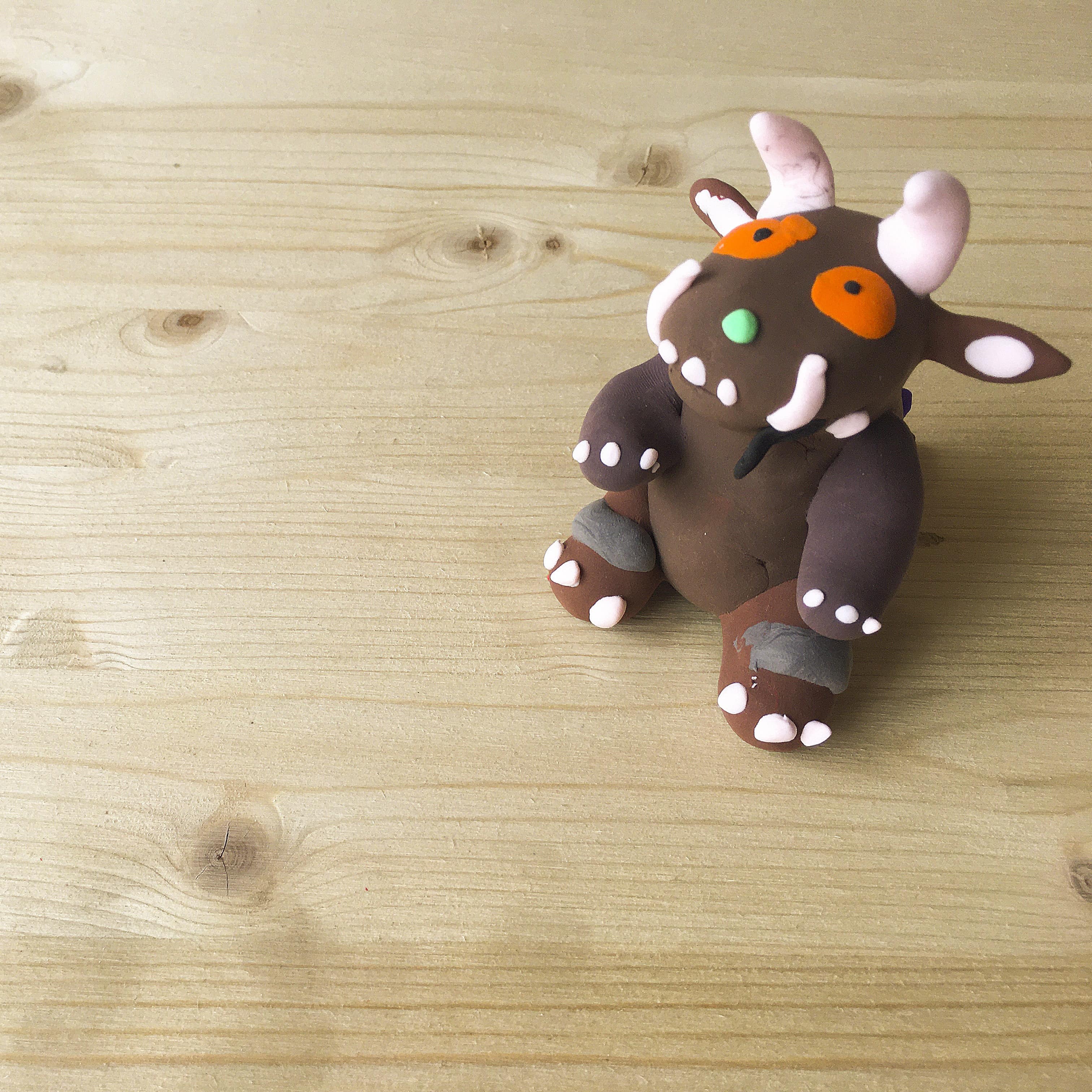 Clay model of the Gruffalo sitting on wood