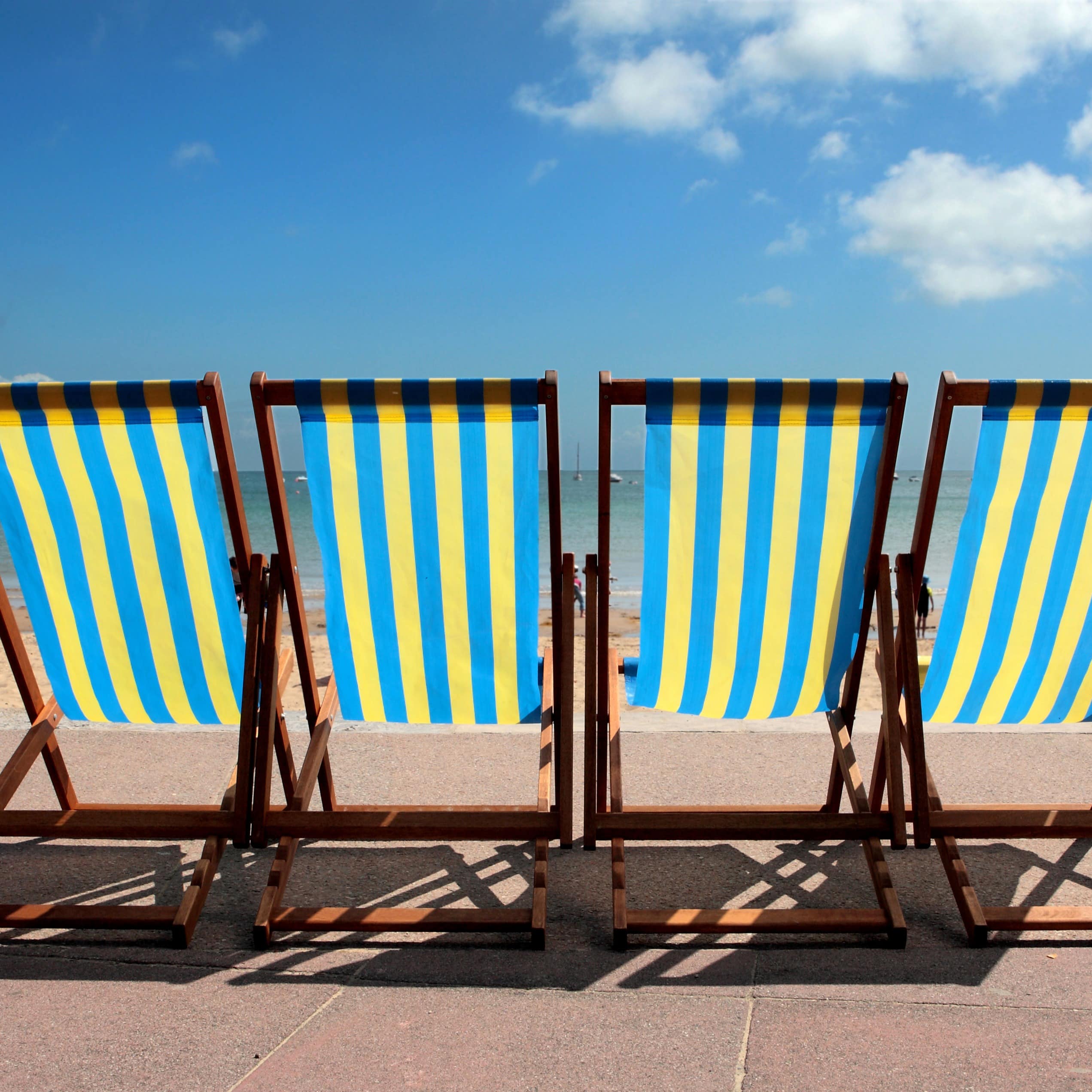 Row of a family's dock chairs at Weymouth Beach in Dorset