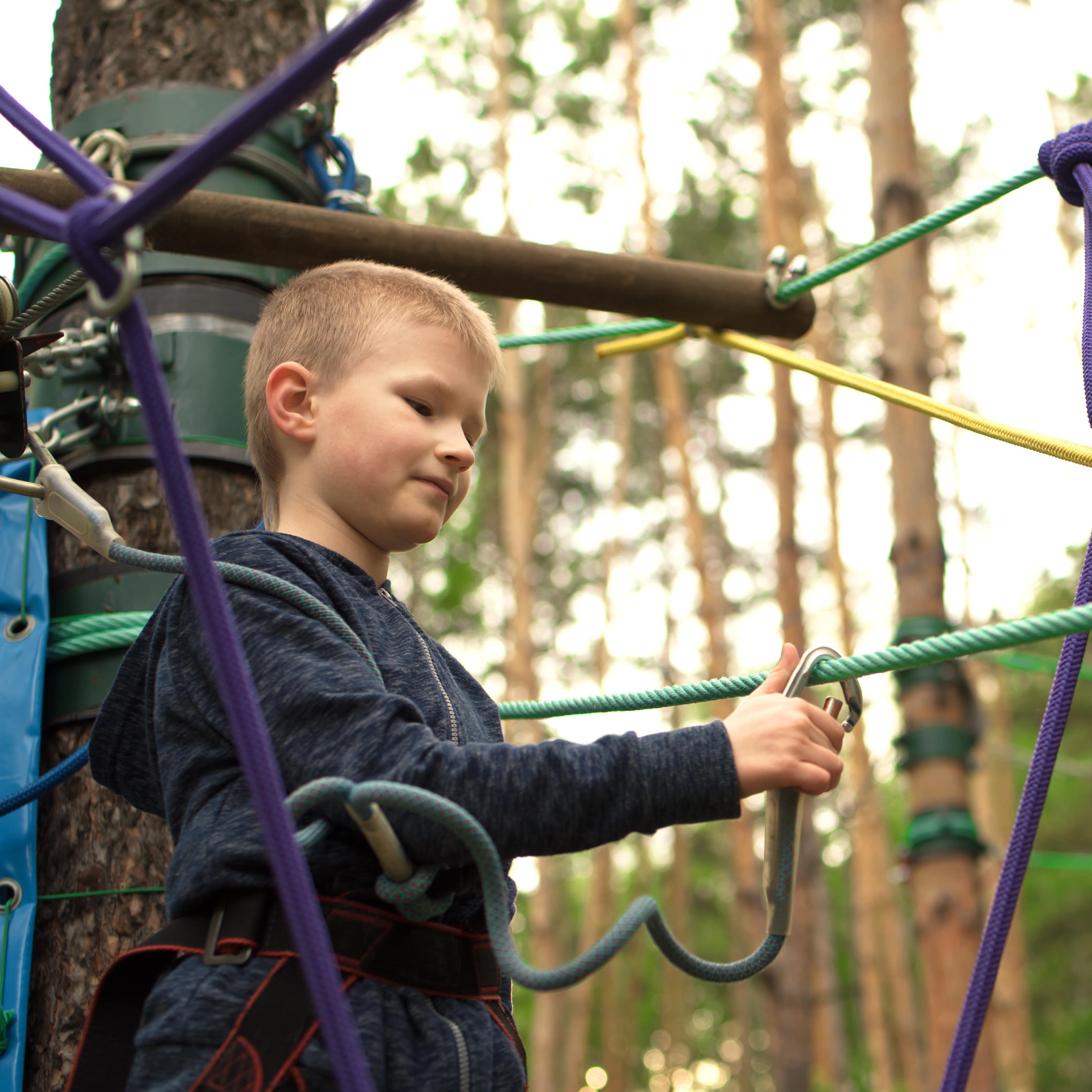 Boy climbing at adventure park