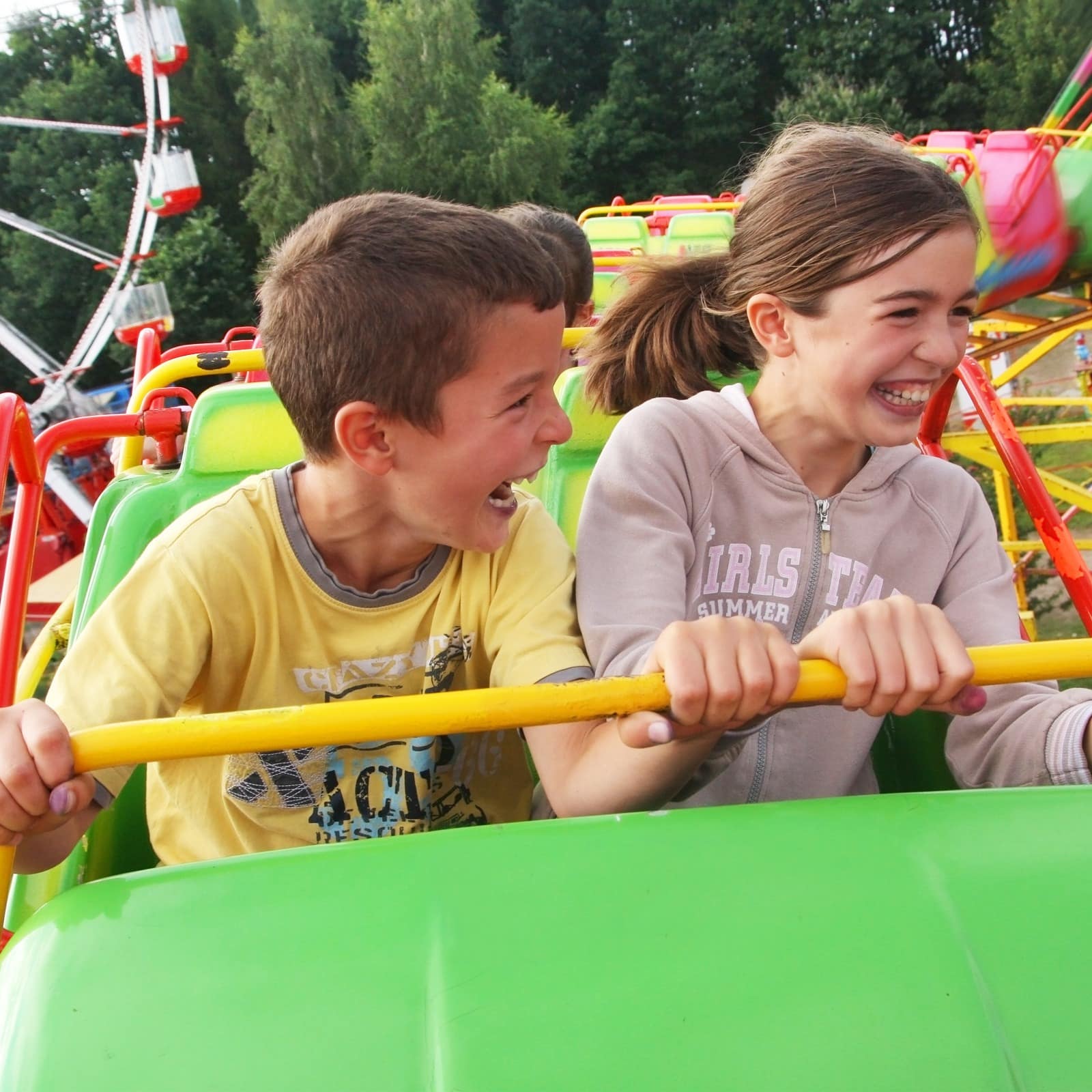 Two kids laughing as they ride on a roller coaster
