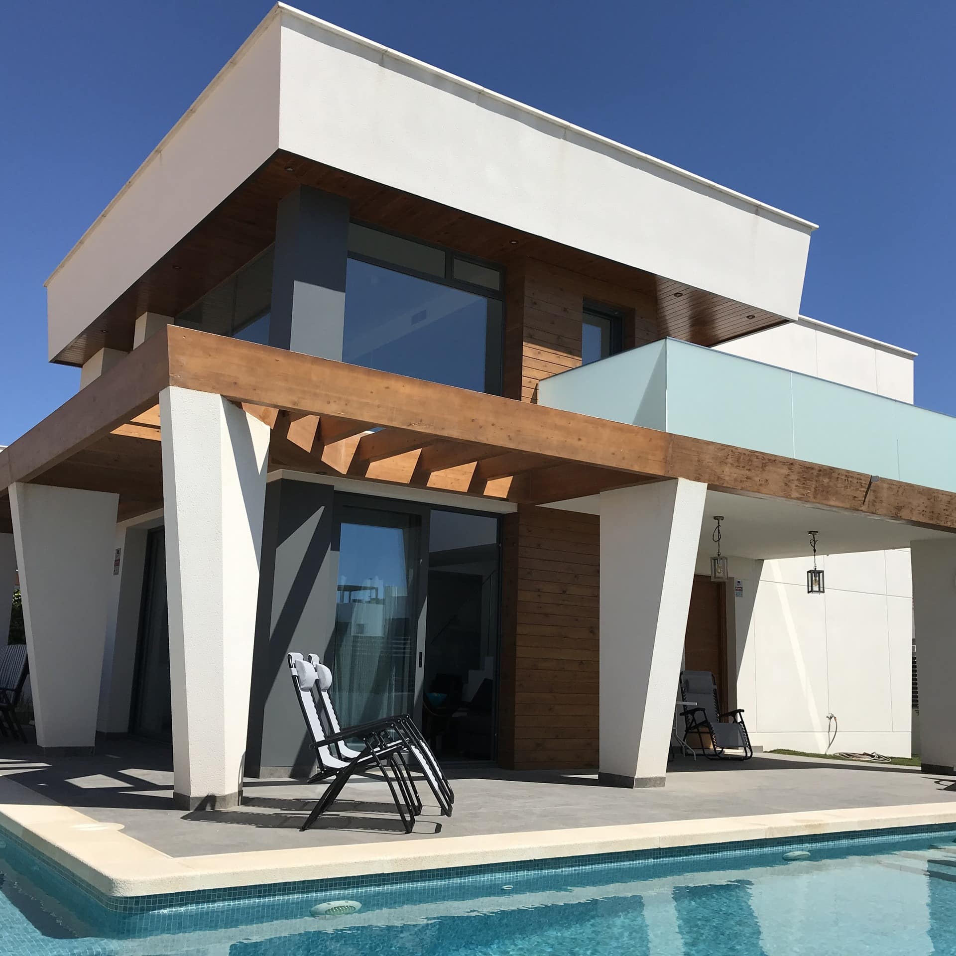 Alojamiento moderno con piscina y tumbonas para pasar un día de verano perfecto