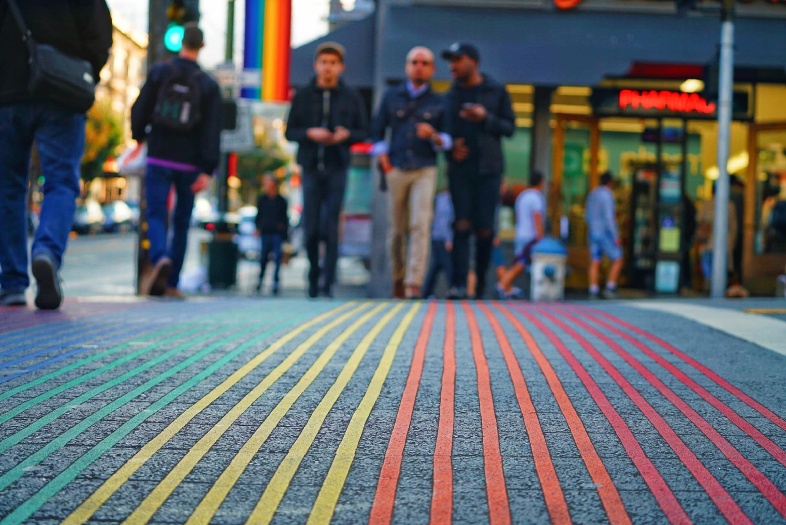 Stock image - Men walking across road in San Francisco USA - gay friendly holiday vacation - Photo by Max Templeton