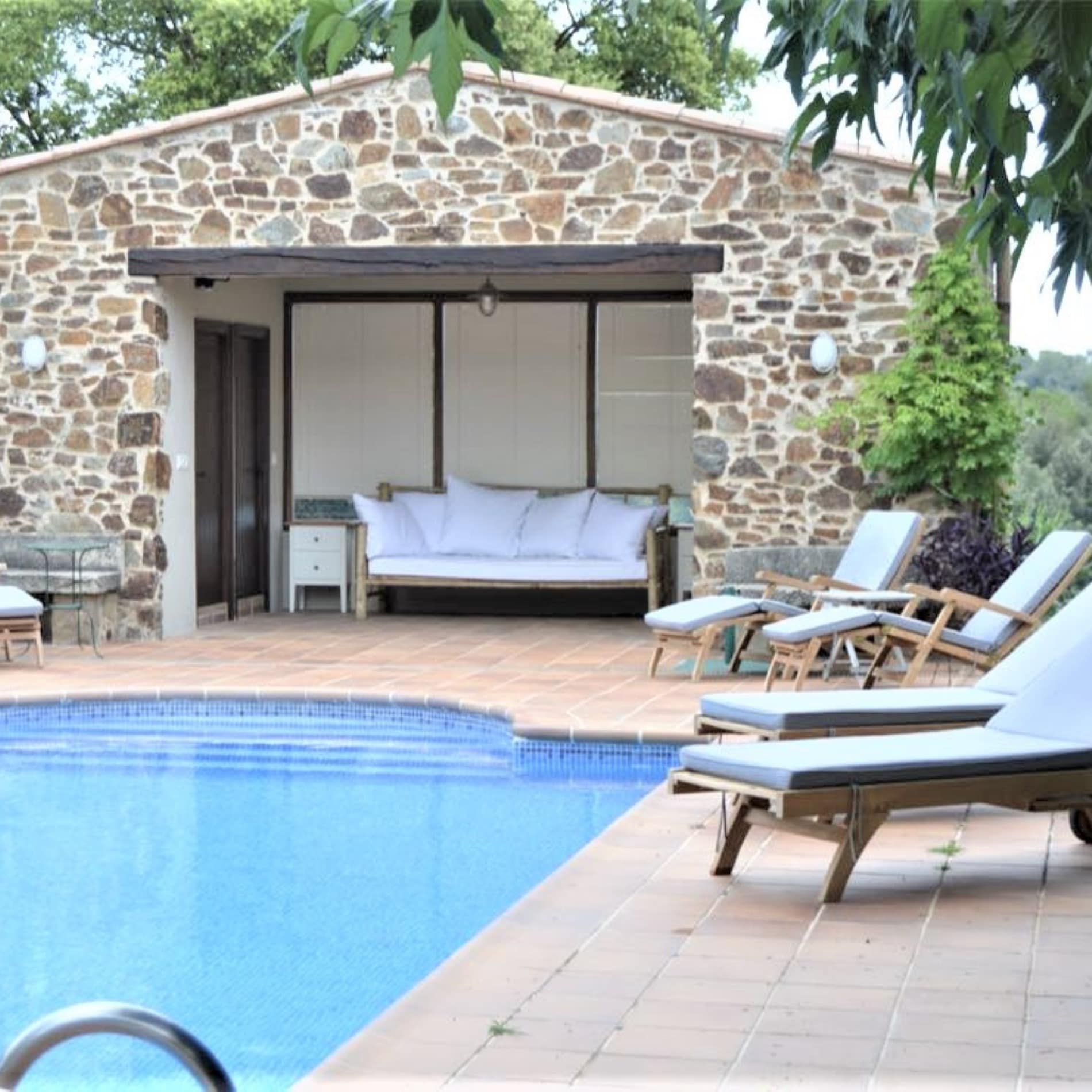 Fantástica piscina con tumbonas y sofá en uno de nuestros alojamientos rurales