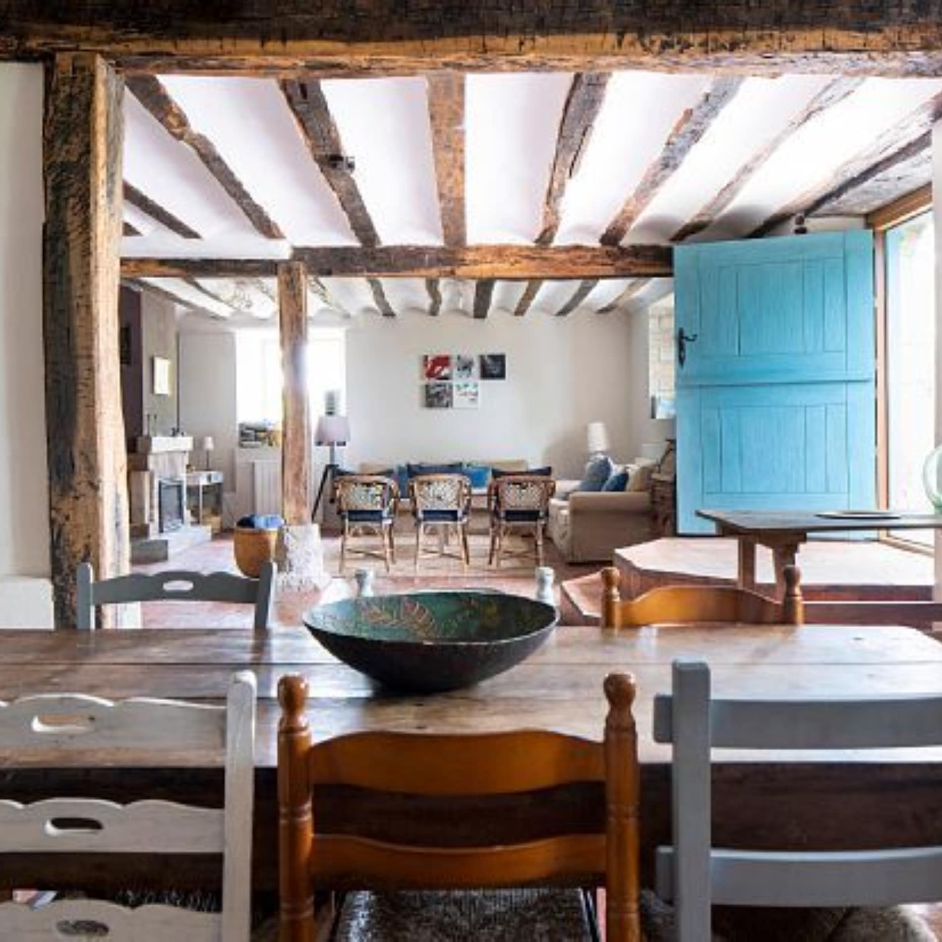 Salón-comedor de casa rural de estilo rústico con muebles y vigas de madera