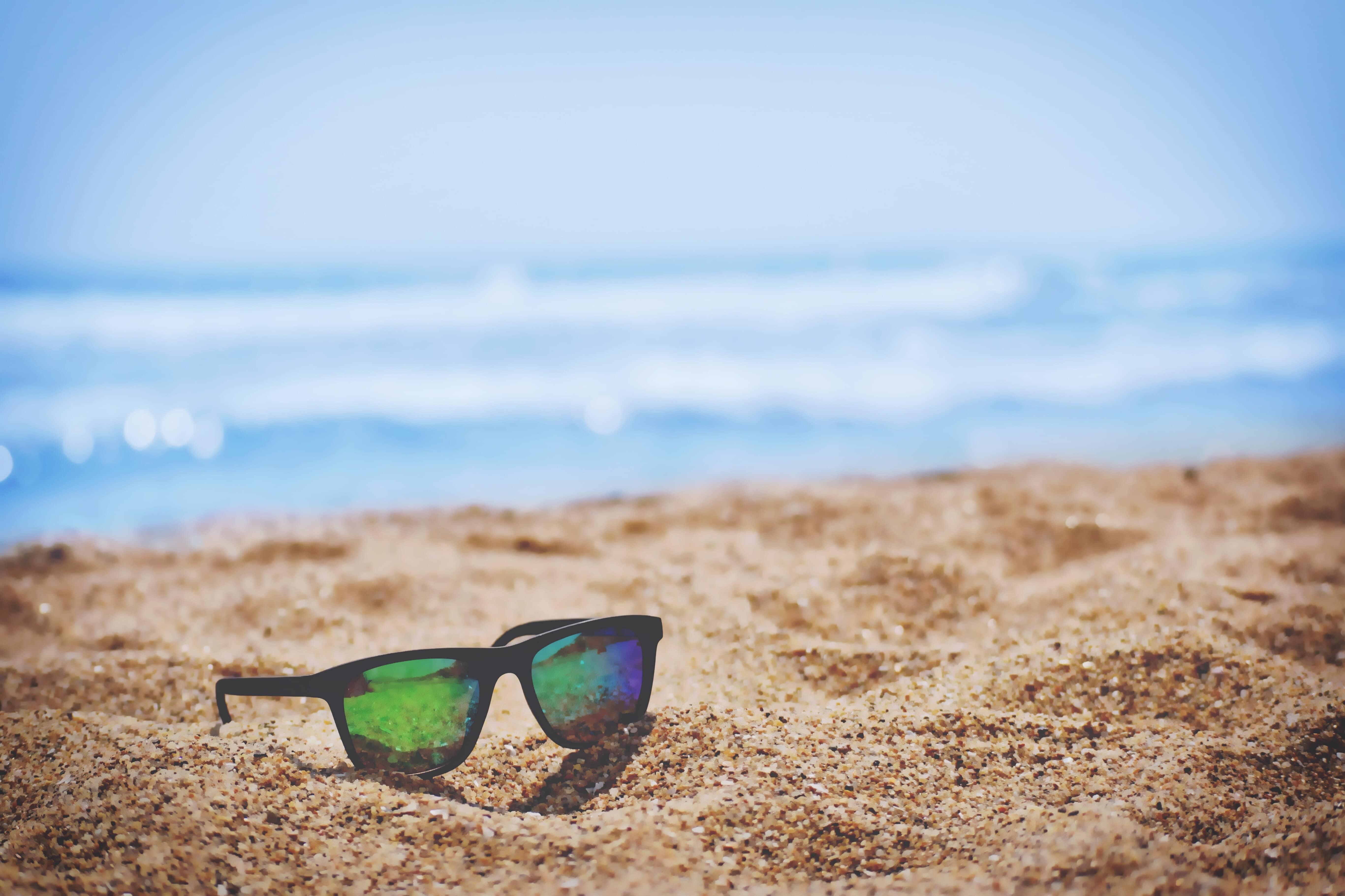 Stock image - Beach holiday, sunglasses on sandy beach - Photo by Sai Kiran Anagani