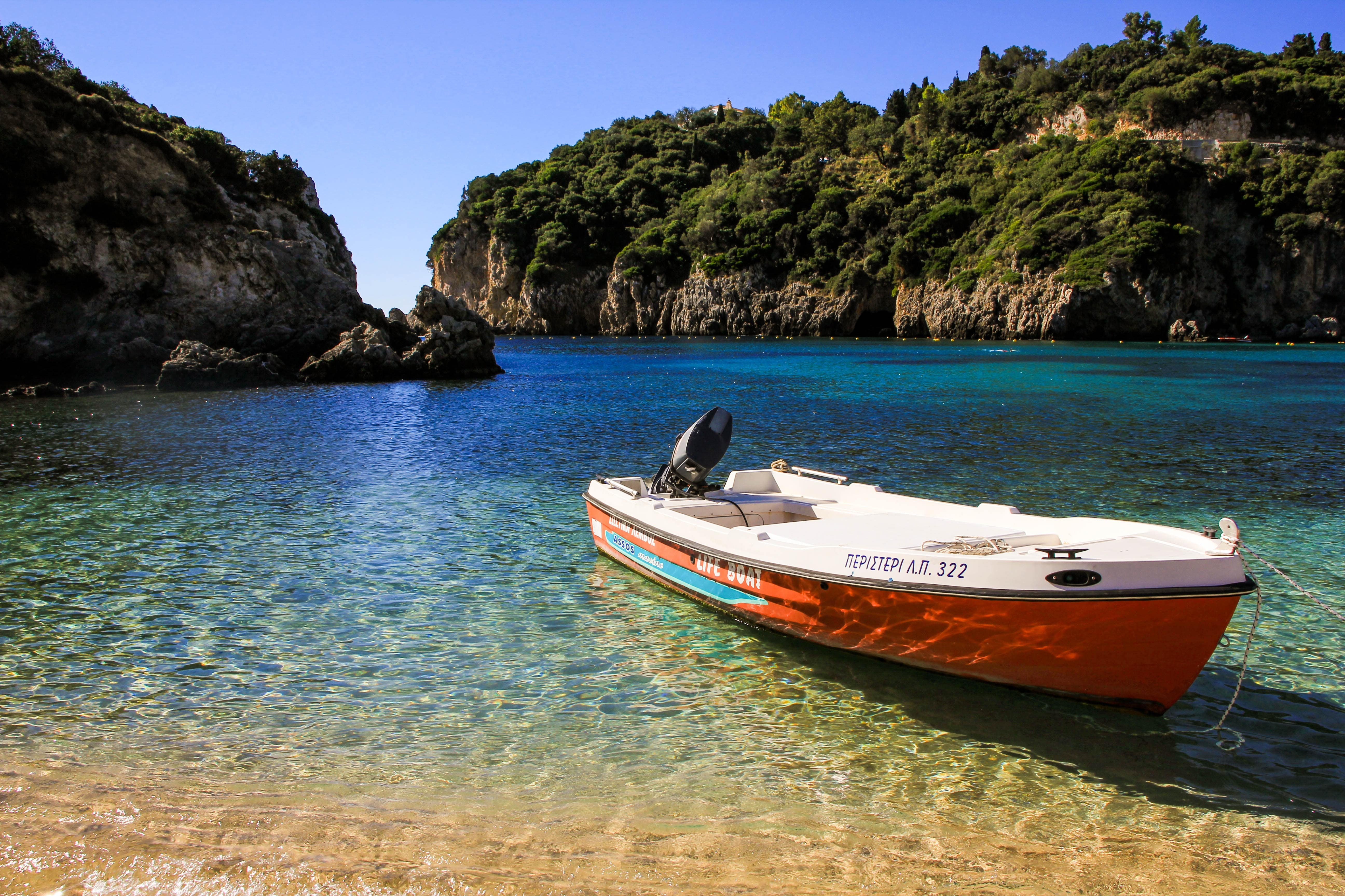 Stock image - Boat in a clear water coastal bay in Corfu, Greece - Photo by Major Wave on Unsplash