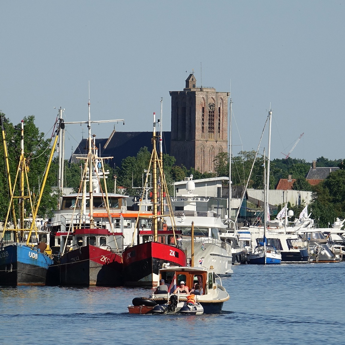  Een haven in de burt van het Veluwemeer met een varend bootje op de voorgrond. 