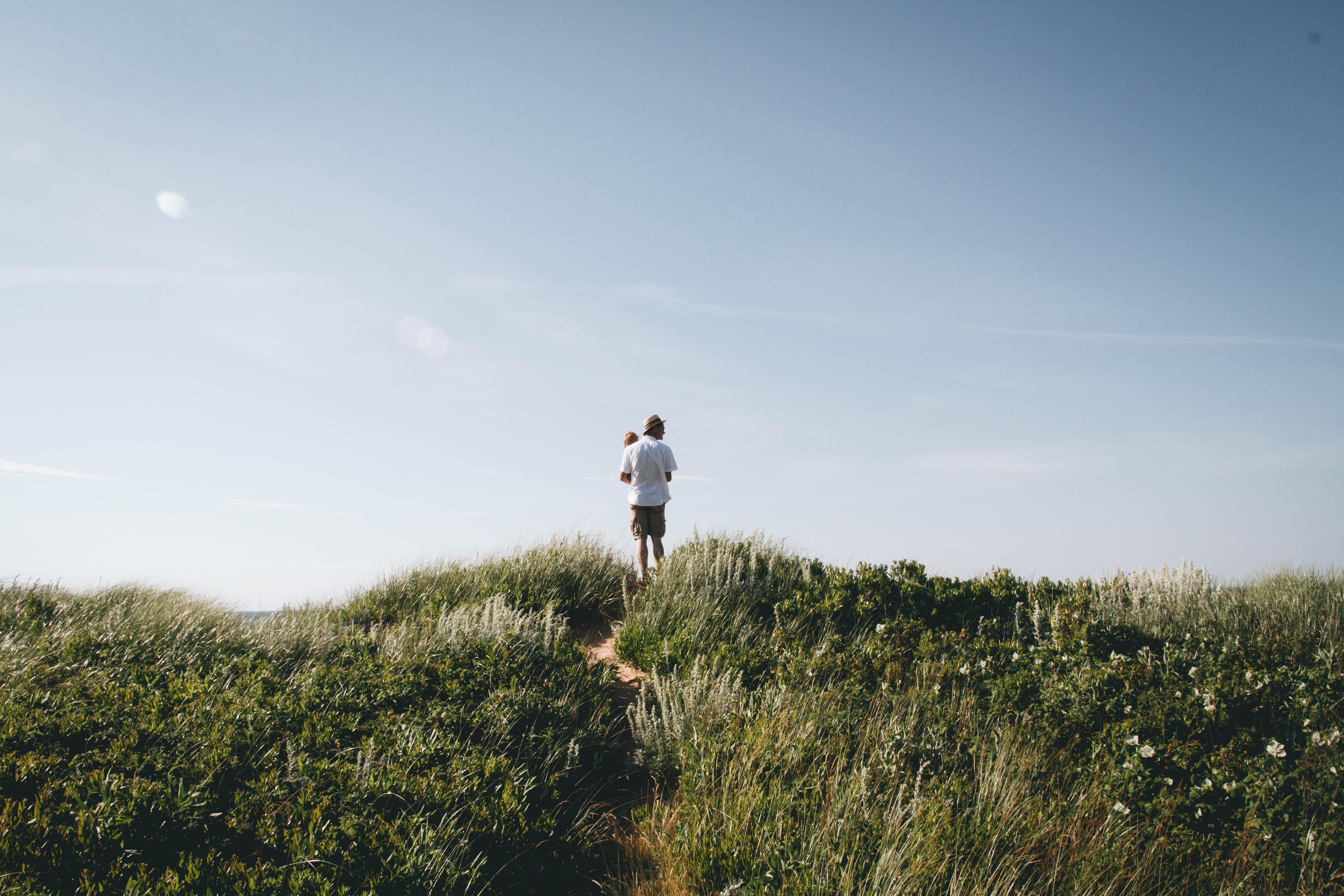 Stock image - Man and baby standing on Prince Edward Island, Canada - Photo by Natalie Toombs on Unsplash