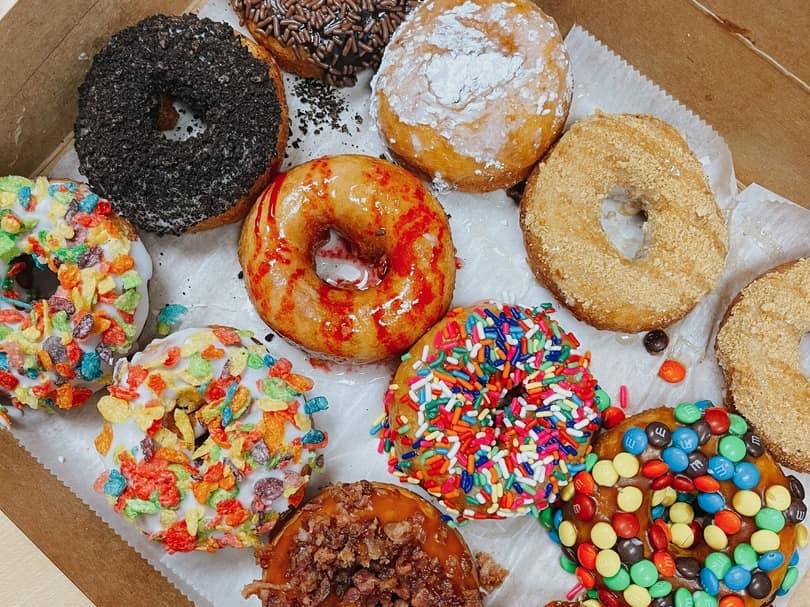 a box of a dozen colorful donuts