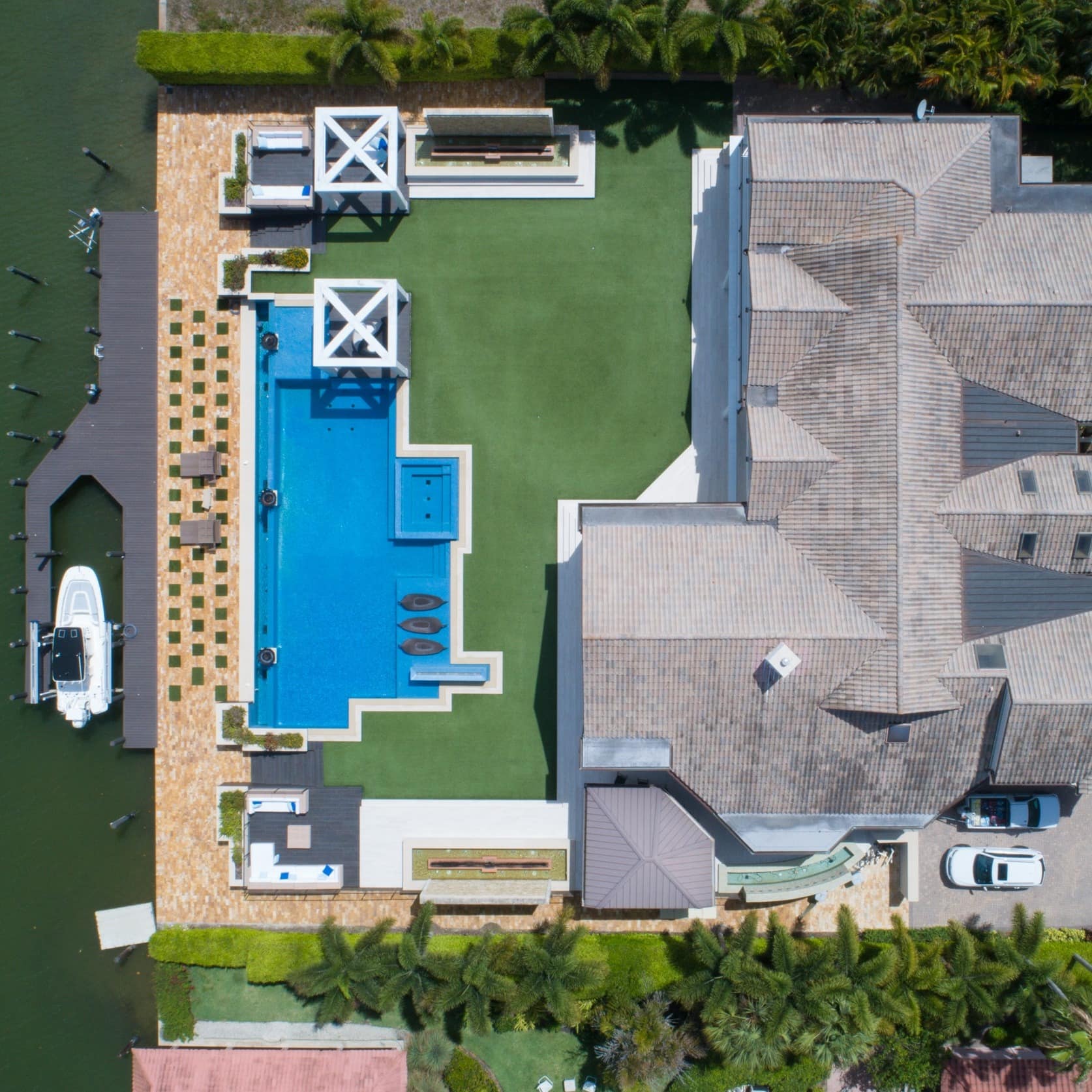 A bird's-eye view of a sumptuous beach mansion in Naples, Florida, with its own marina and pool
