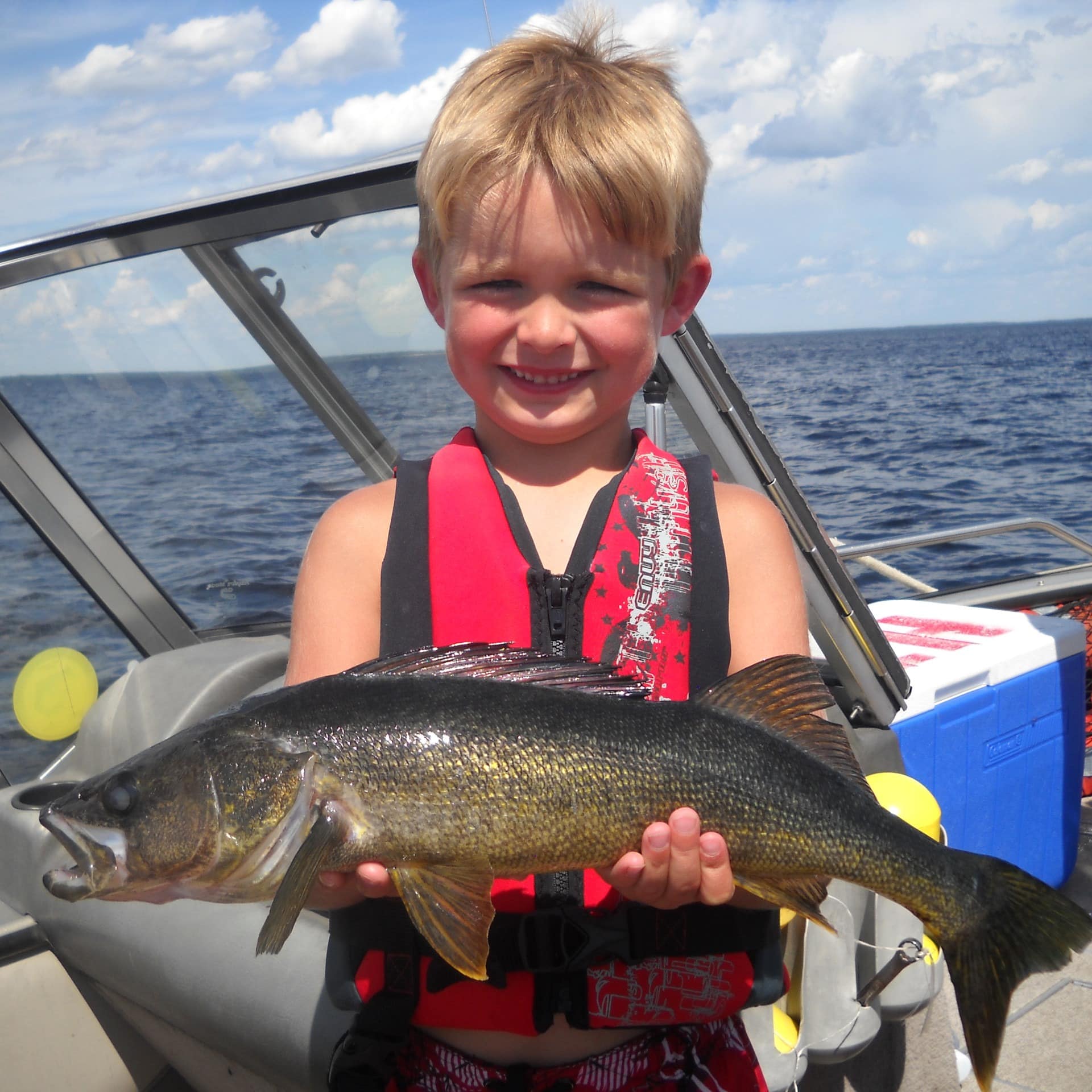 A young boy shows off a fish caught in Rainy Lake