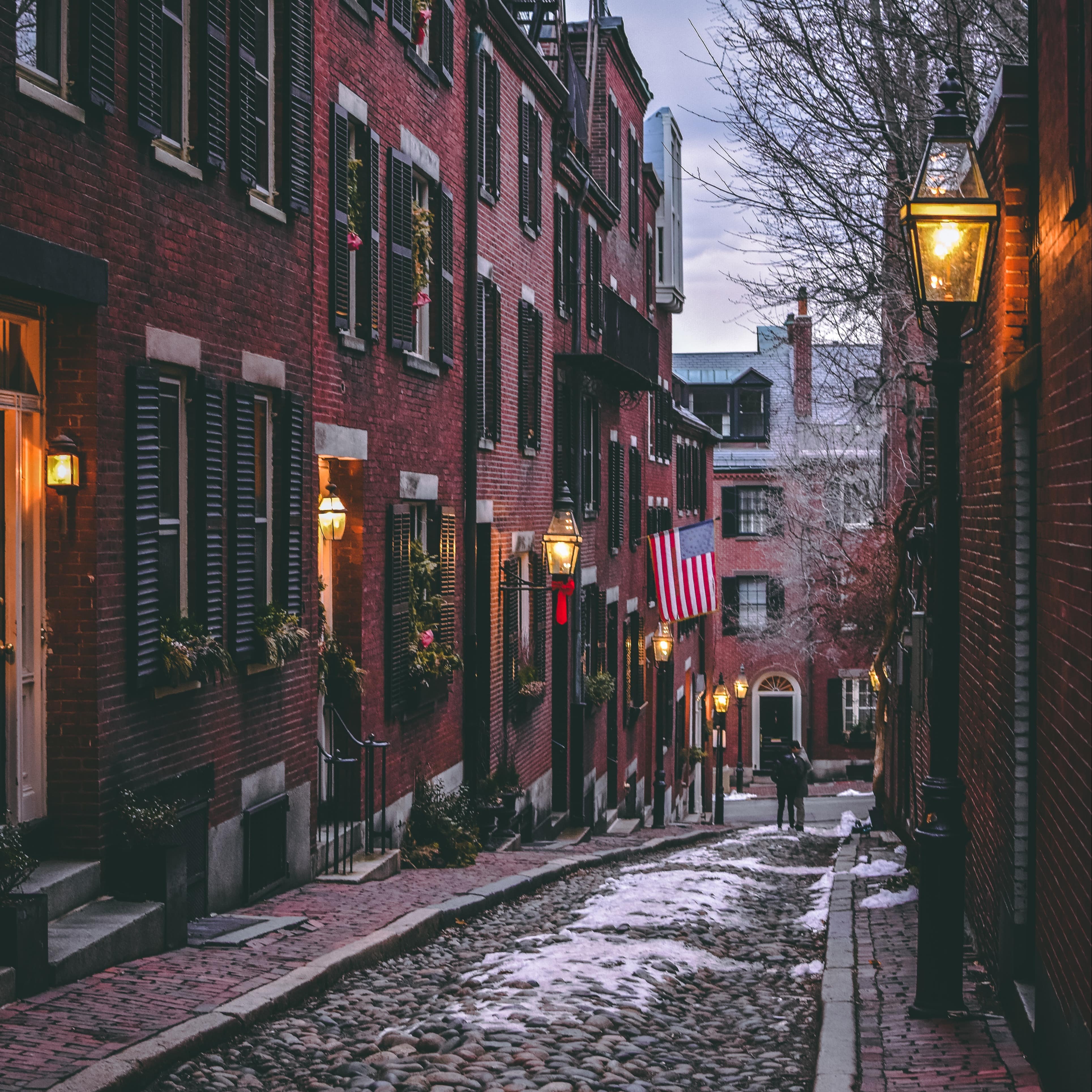 A cobblestone street lined with brick buildings in Boston, MA
