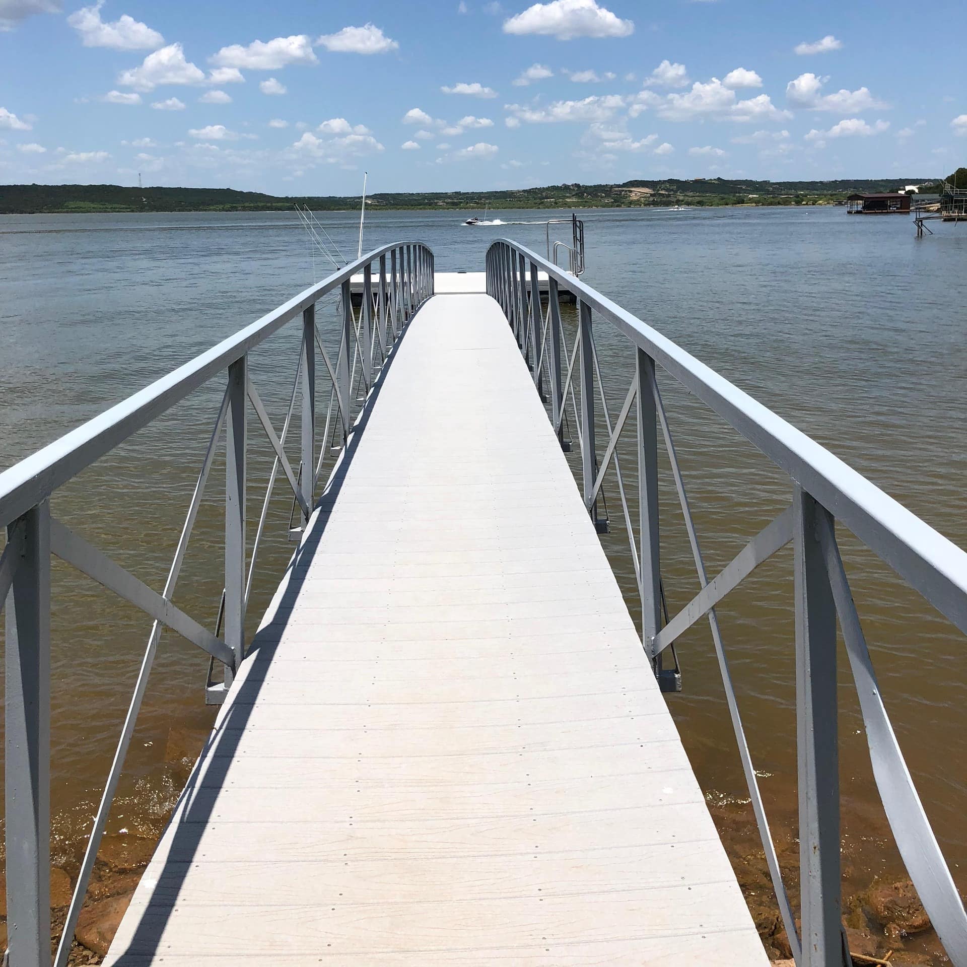 A private dock stretching over a lake on a sunny day