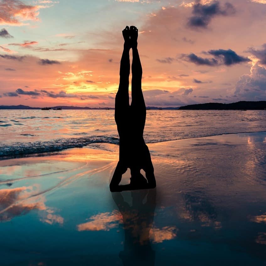 A girl practicing yoga on the beach