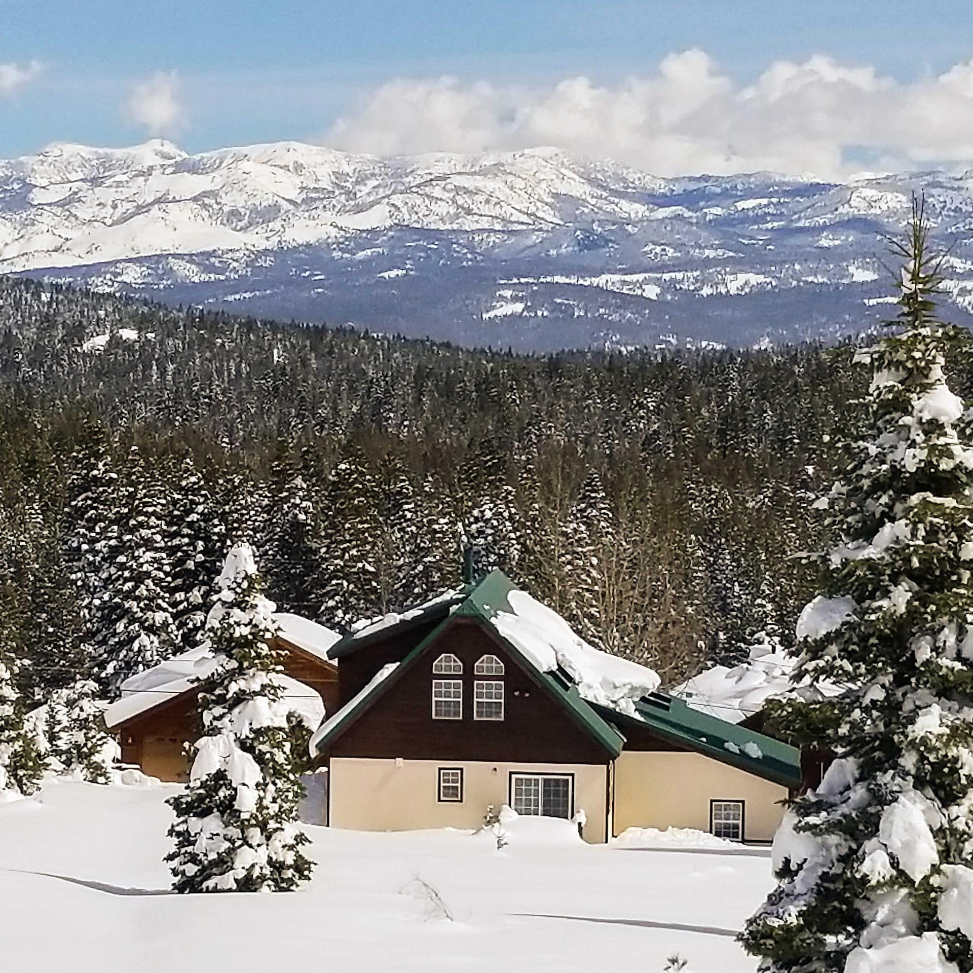 Cabin in snow with mountains in the background