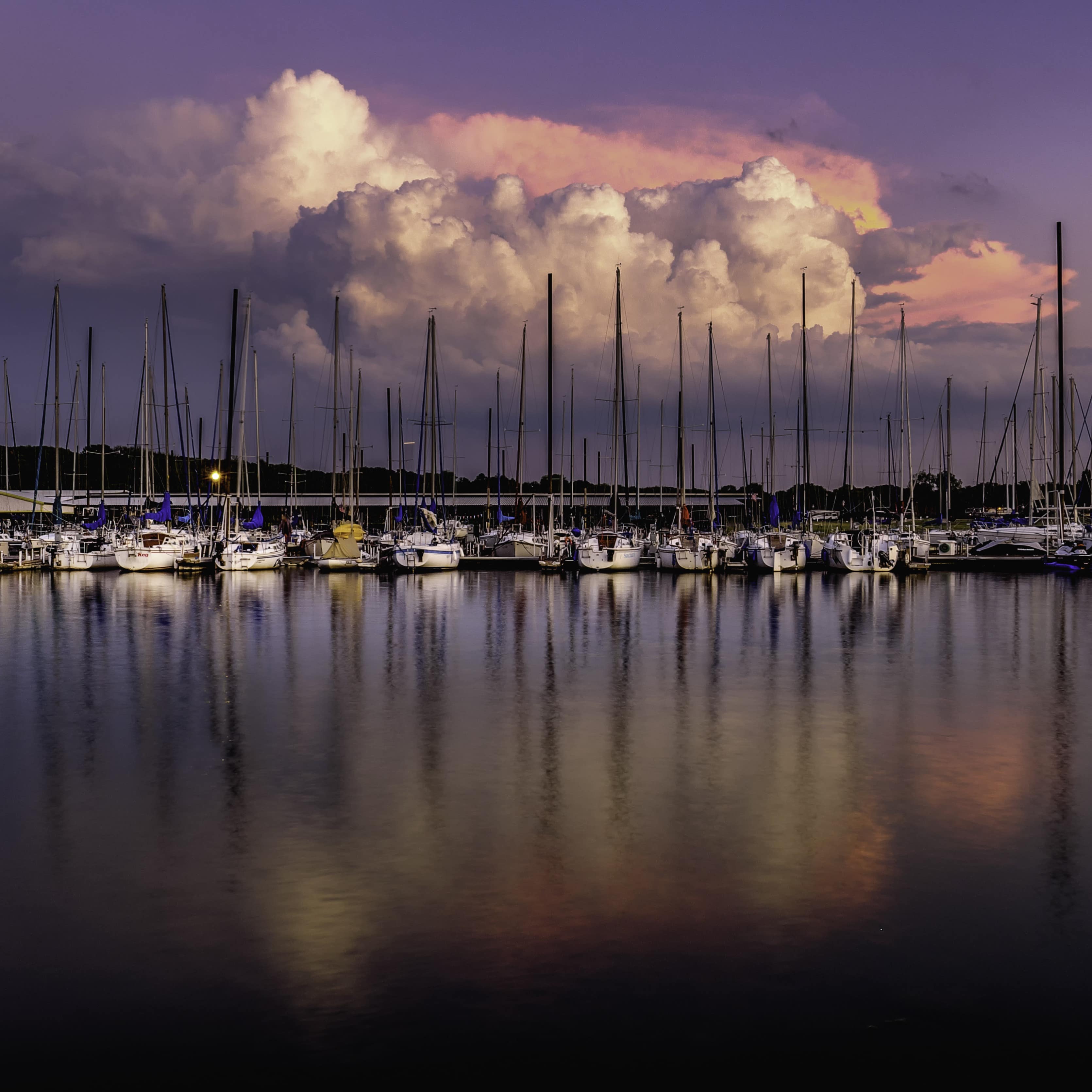 Sailboats at marina at Grapevine, Texas with puffy colorful clouds in background