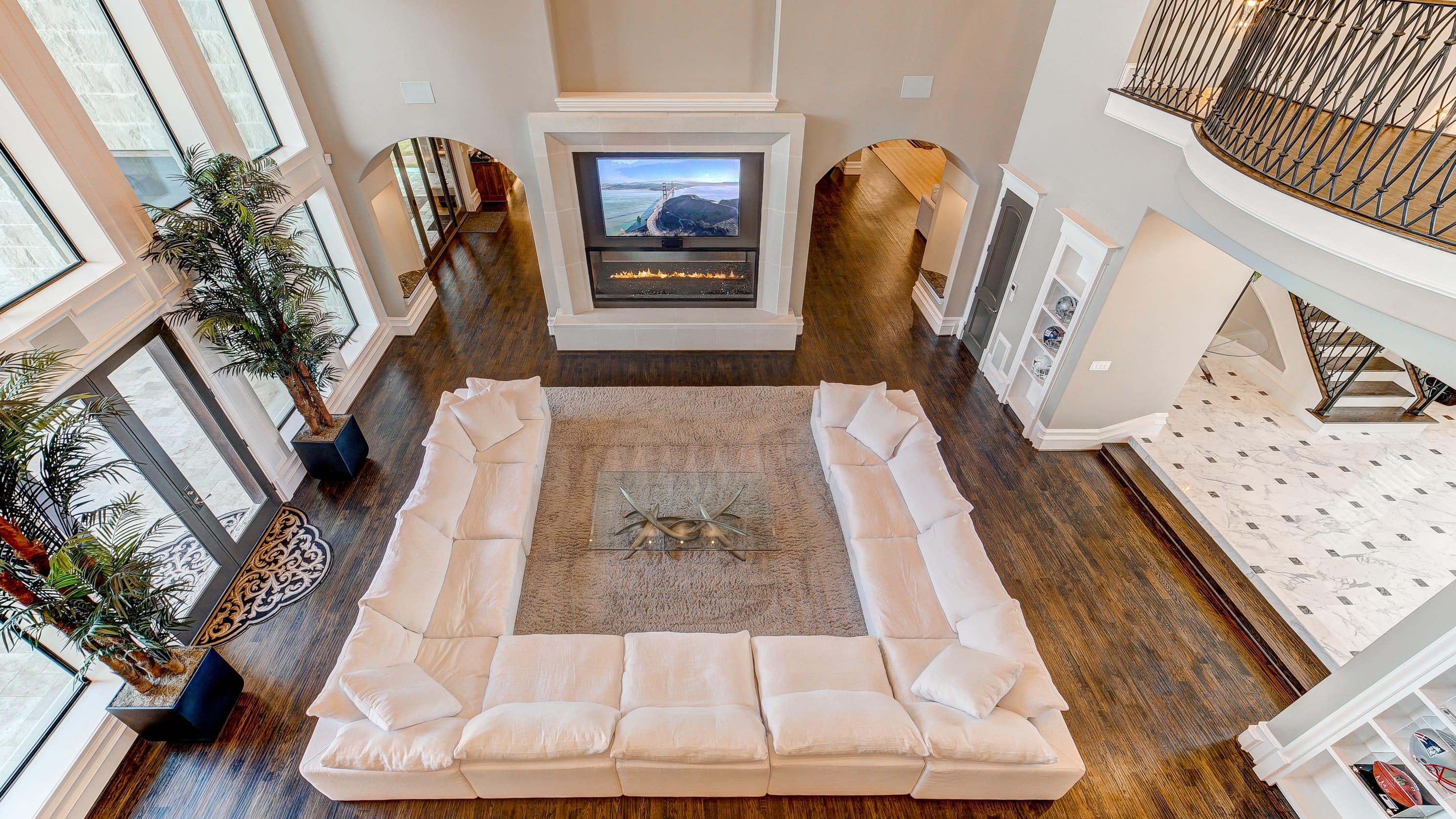 An uber-stylish living room with a massive TV, fireplace, and sofa