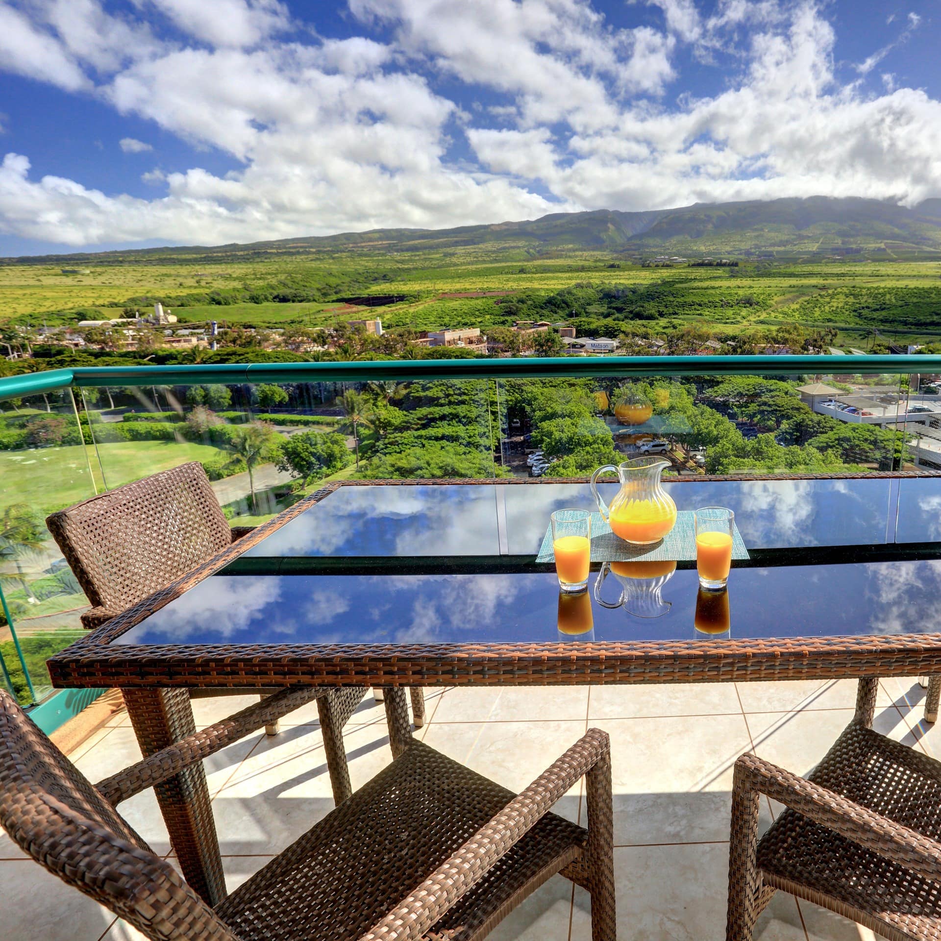Dining area on a deck that offers views of verdant fields and distant mountains