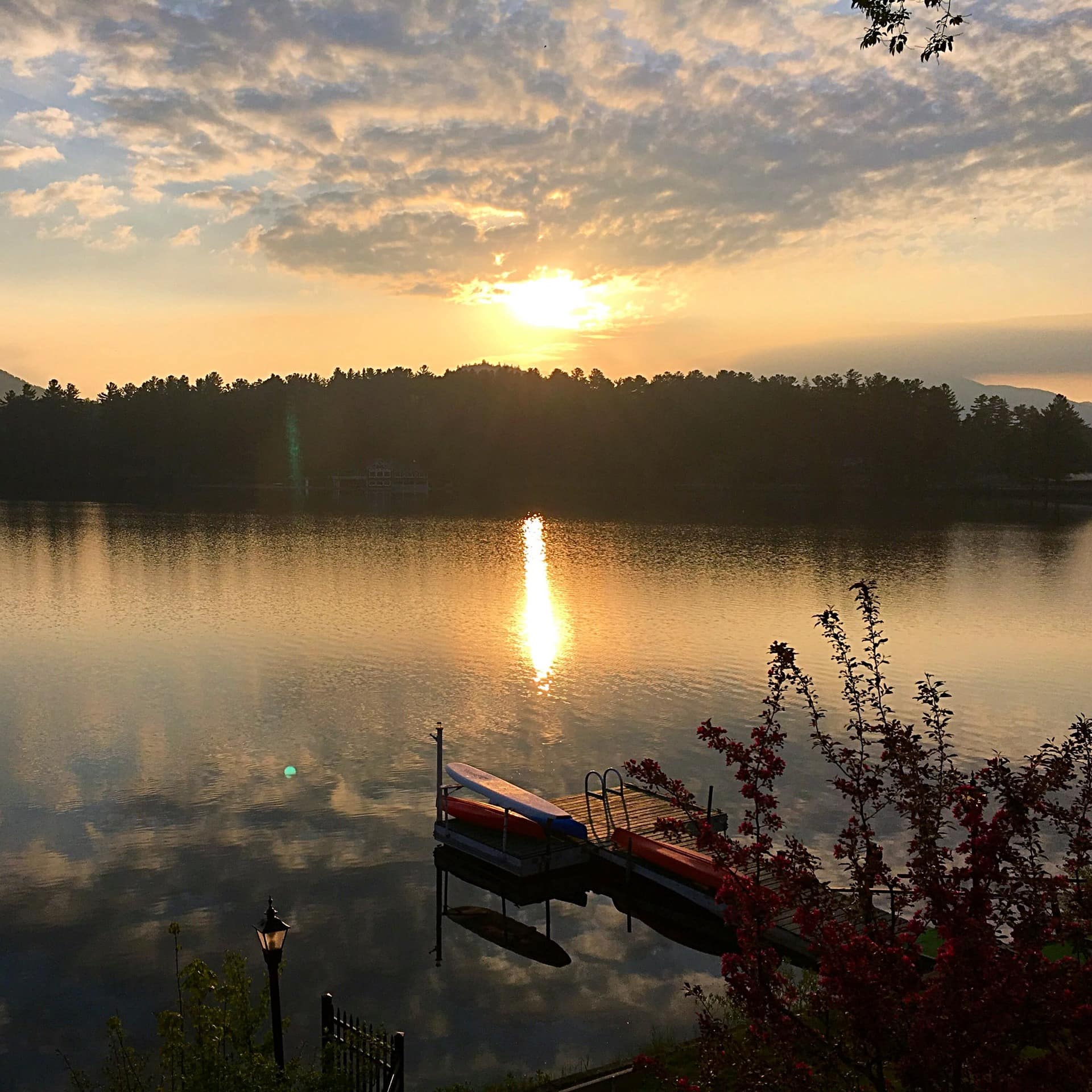 Boats docked on a lake at sunset